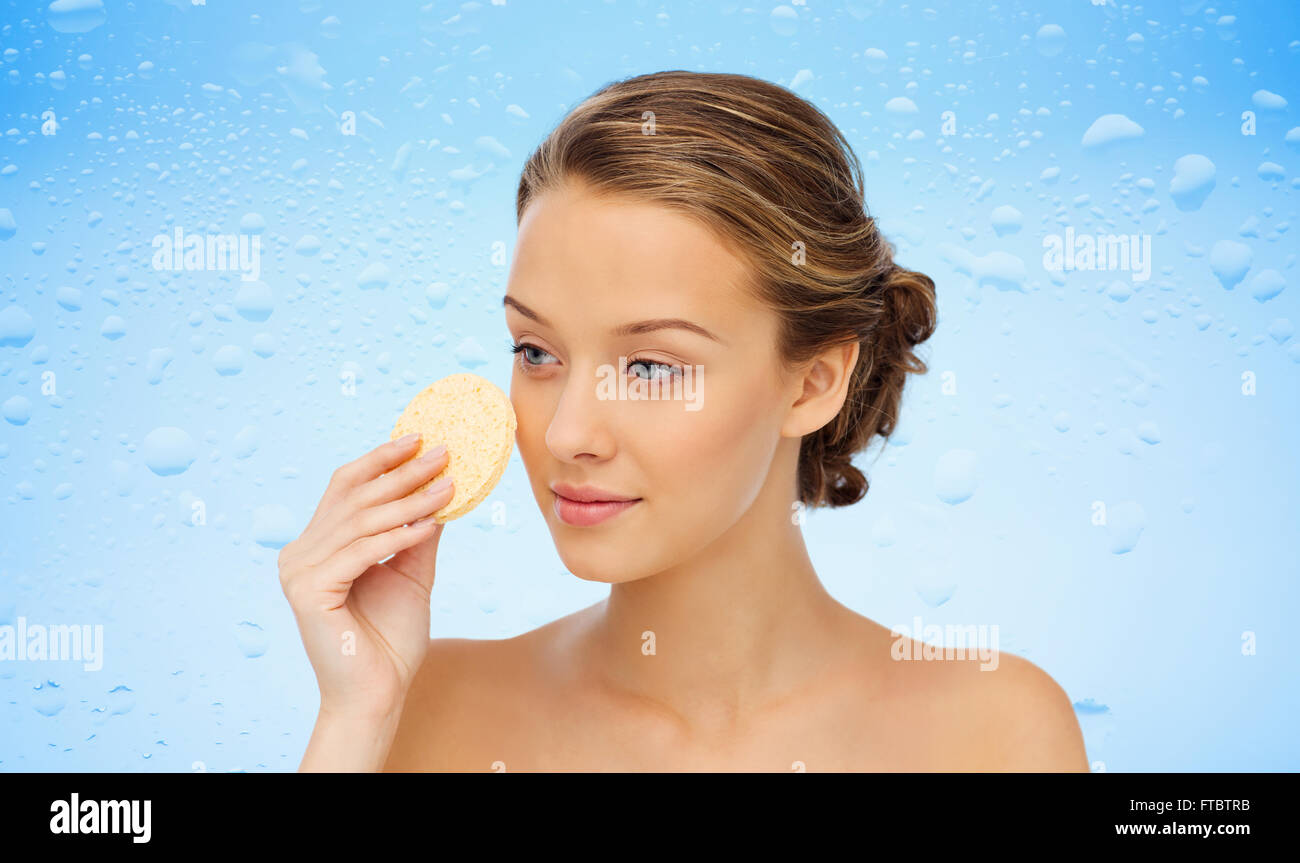 young woman cleaning face with exfoliating sponge Stock Photo