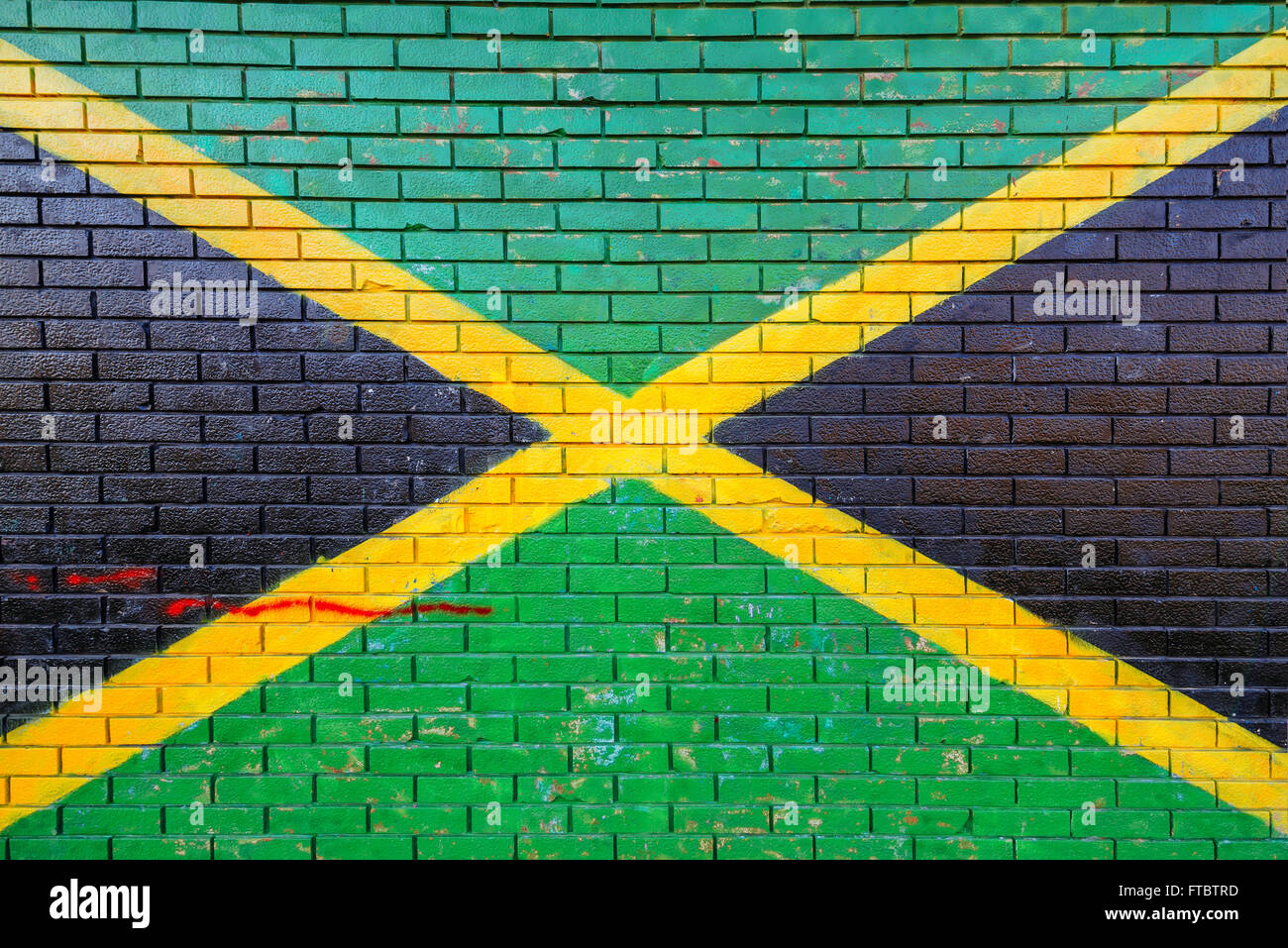 Jamaica flag painted on brick wall in urban environment Stock Photo
