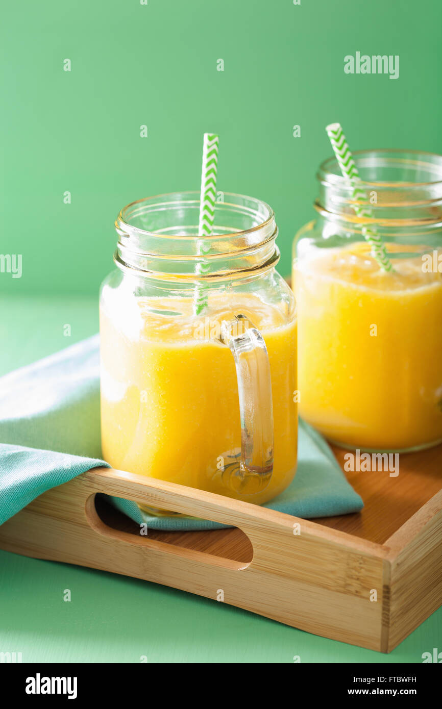 healthy mango pineapple smoothie in mason jars Stock Photo