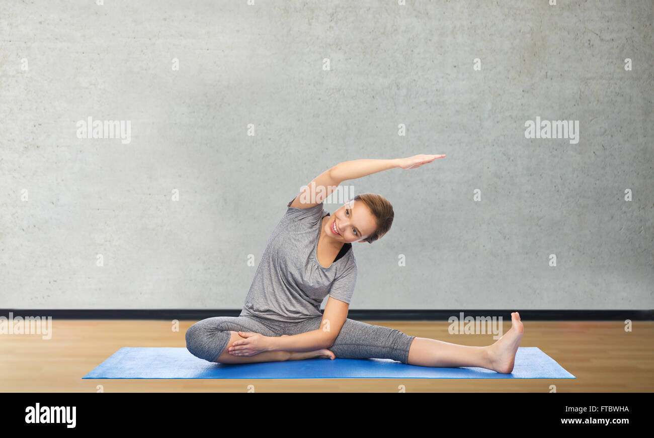 happy woman making yoga and stretching on mat Stock Photo - Alamy