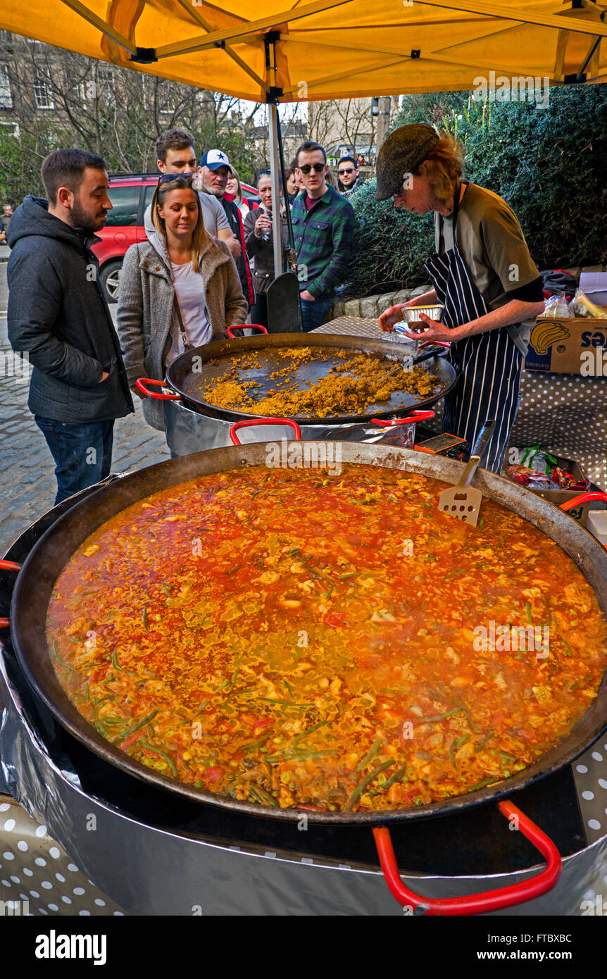 A young man serving paella at a stall in Stockbridge Sunday Market in Edinburgh. Stock Photo