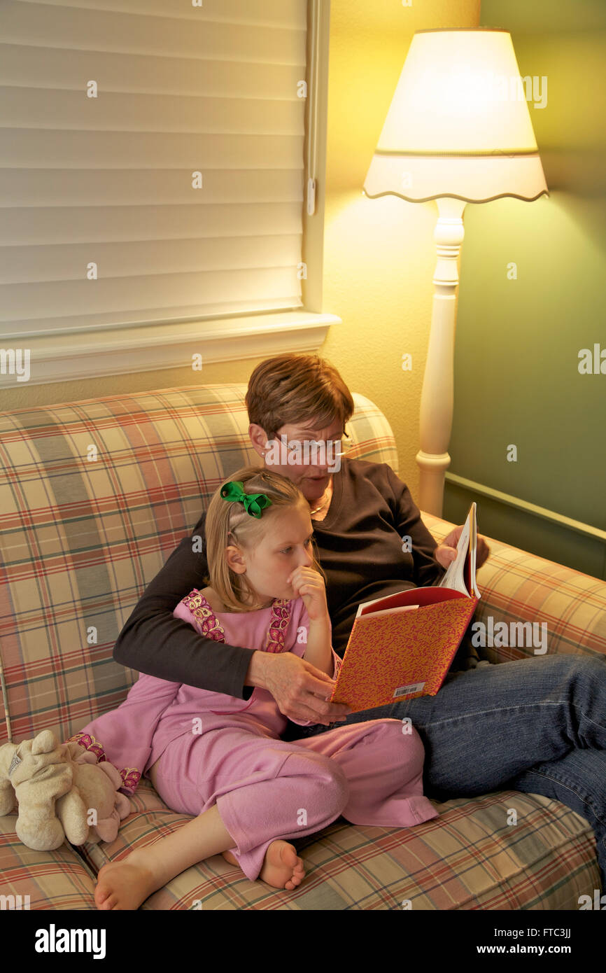 Grandmother reading to her granddaughter Stock Photo