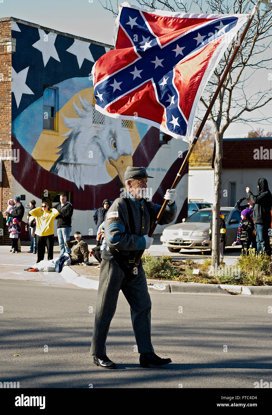 Emporia, Kansas, USA, 11th November, 2014 Man with Confederate flag and uniform marches by himself in the annual veterans day parade in Emporia Kansas. In 1953, Emporia was the site of the first Veterans Day observance in the United States. At the urging of local shoe cobbler Alvin J. King, U.S. Representative Edward Rees introduced legislation in The United States Congress to rename Armistice Day as Veterans Day. President Dwight D. Eisenhower signed the bill into law on October 8, 1954 Credit: Mark Reinstein Stock Photo