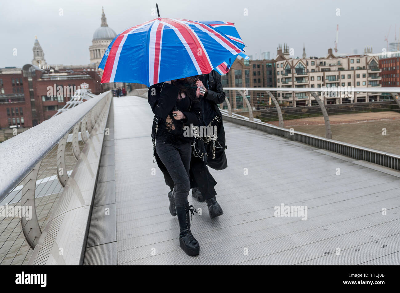 London, UK. 27 March 2016. Tourists and Londoners in the rain crossing