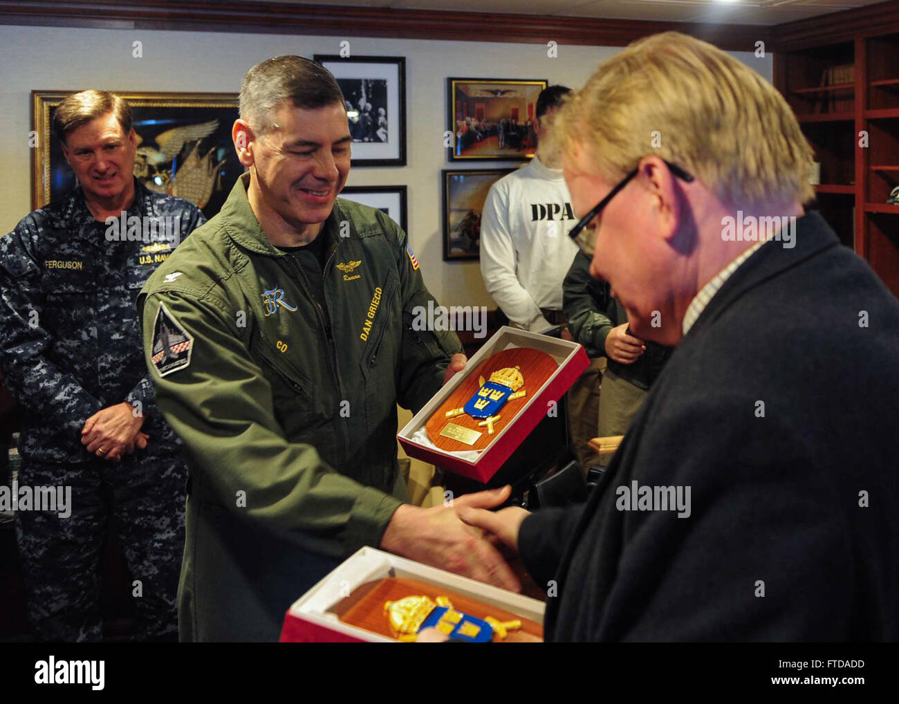 150322-N-ZZ999-031 ATLANTIC OCEAN (March 22, 2015) Commanding Officer of the Nimitz-class aircraft carrier USS Theodore Roosevelt (CVN 71) Capt. Daniel Grieco, left, receives a token of appreciation from the Swedish Minister of Defence Peter Hultqvist aboard Theodore Roosevelt March 22, 2015. Theodore Roosevelt, homeported in Norfolk, is conducting naval operations in the U.S. 6th Fleet area of operations in support of U.S. national security interests in Europe. (U.S. Navy photo by Mass Communication Specialist Seaman Anthony Hopkins II/Released) Stock Photo