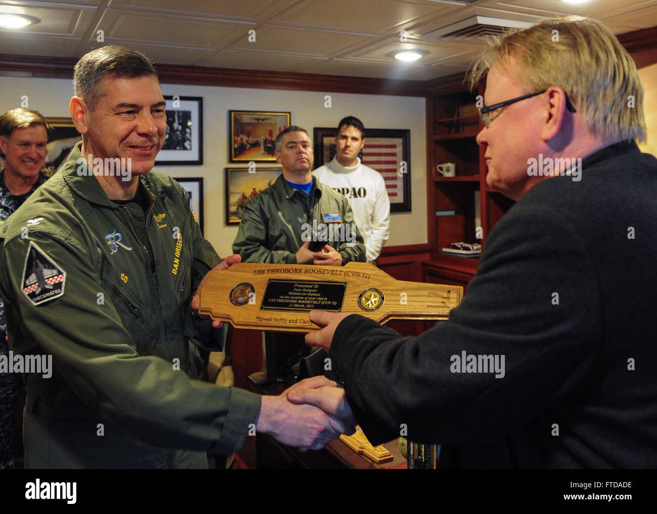 150322-N-ZZ999-034 ATLANTIC OCEAN (March 22, 2015)  Commanding Officer of the Nimitz-class aircraft carrier USS Theodore Roosevelt (CVN 71) Capt. Daniel Grieco, left, presents a token of appreciation to the Swedish Minister of Defence Peter Hultqvist aboard Theodore Roosevelt March 22, 2015. Theodore Roosevelt, homeported in Norfolk, is conducting naval operations in the U.S. 6th Fleet area of operations in support of U.S. national security interests in Europe. (U.S. Navy photo by Mass Communication Specialist Seaman Anthony Hopkins II/Released) Stock Photo