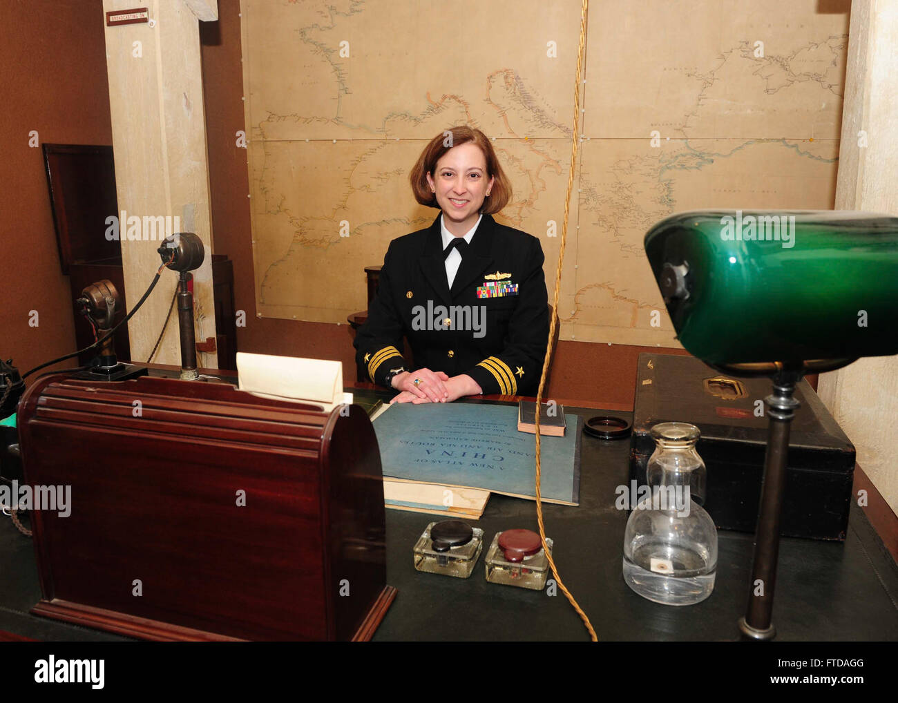 150324-N-BD333-088 PORTSMOUTH, United Kingdom (March 24, 2015) Cmdr. Christine O'Connell, commanding officer of the Arleigh-Burke class guided missile destroyer USS Winston S. Churchill (DDG 81), sits in Sir Winston S. Churchill’s chair in his office-bedroom during a tour of the Churchill War Rooms museum in London, March 24, 2015. Theodore Roosevelt Carrier Strike Group (TRCSG) leadership also attended the tour of the museum. Churchill, home-ported in Norfolk, is conducting naval operations in the U.S. 6th Fleet area of operations in support of U.S. national security interests in Europe. (U.S Stock Photo