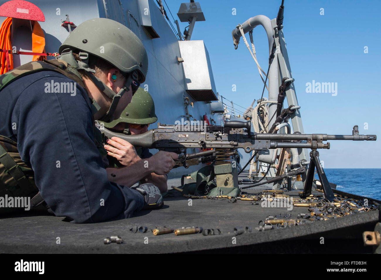 150403-N-VC236-140 MEDITERRANEAN SEA (April 3, 2015) - Gunner's Mate 2nd Class Alan Bishop, from Orlando, Florida, looks on as Operations Specialist Will Farmer, from Columbia, South Carolina, fires a M240 machine gun during a live-fire exercise aboard the Arleigh Burke-class guided-missile destroyer USS Farragut (DDG 99) April 3, 2015. Farragut, homeported in Mayport, Florida, is conducting naval operations in the U.S. 6th Fleet area of operations in support of U.S. national security interests in Europe. (U.S. Navy photo by Mass Communication Specialist 3rd Class Jackie Hart/Released) Stock Photo