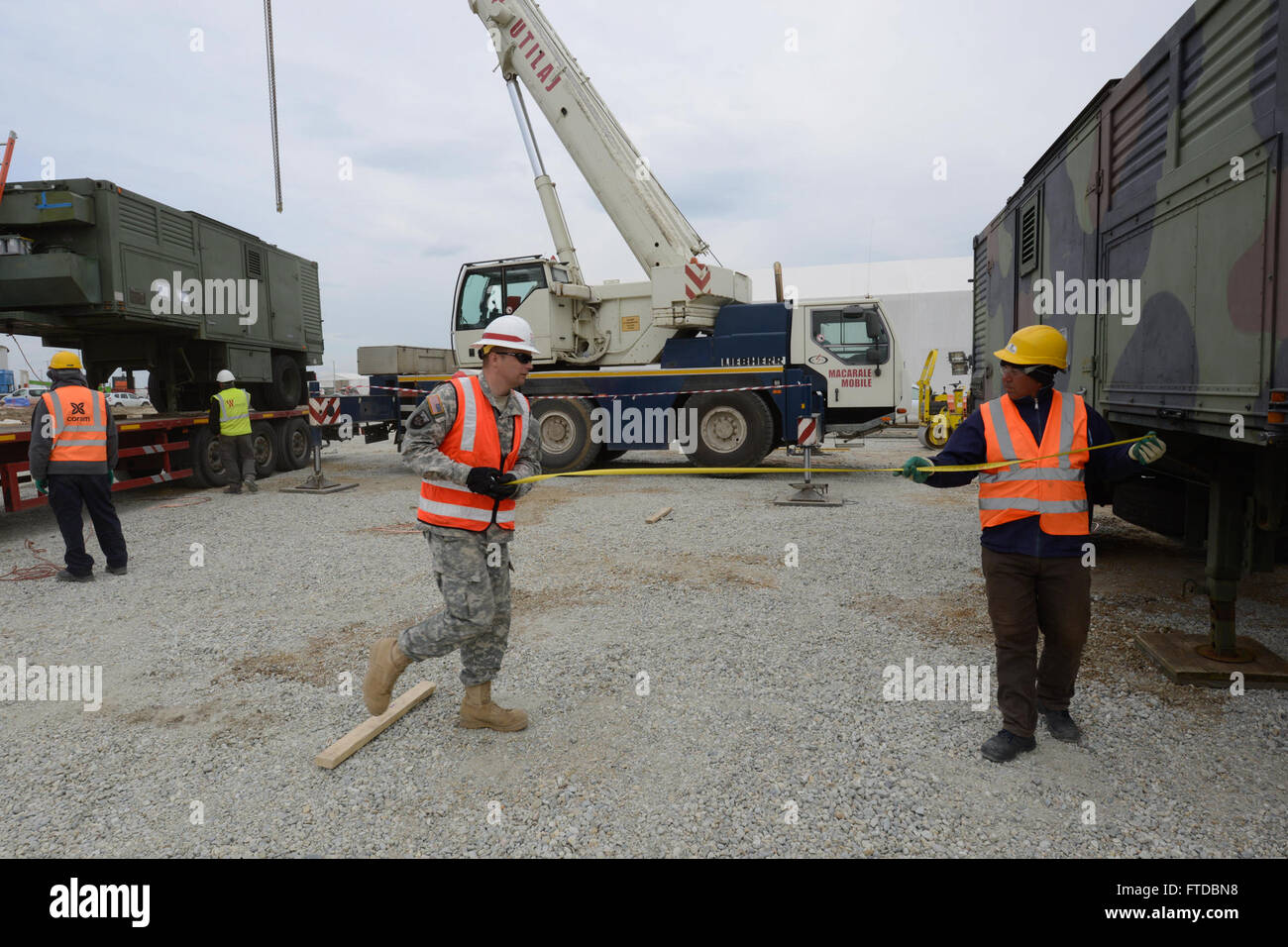 150418-N-TQ904-024 NAVAL SUPPORT FACILITY DEVESELU, Romania (April 18, 2015) Sgt. 1st Class Aaron Norris works with civilian contractors to install a generator at Naval Support Facility Deveselu, Romania, April 18, 2015. Members of the U.S. Army Corps of Engineers 249th Engineer Battalion transported four generators from Fort Belvoir, Virginia, and installed them into Deveselu’s Aegis Ashore facility. (U.S. Navy photo by Lt. Cmdr. Mike Billips/Released) Stock Photo