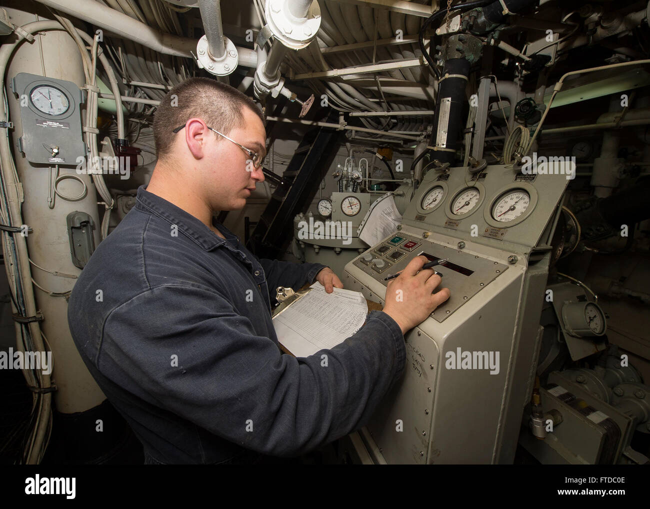 150424-N-FQ994-056 LARNACA, Cyprus (April 24, 2015) Gas Turbine Systems Technician (Mechanical) Fireman Lonnie Atkins, from Greenfield, Ohio, takes temperature and pressure readings from the 2LPAC (low pressure air compressor) aboard USS Ross (DDG 71) April 24, 2015.  Ross, an Arleigh Burke-class guided-missile destroyer, forward-deployed to Rota, Spain, is conducting naval operations in the U.S. 6th Fleet area of operations in support of U.S. national security interests in Europe.  (U.S. Navy photo by Mass Communication Specialist 3rd Class Robert S. Price/Released) Stock Photo