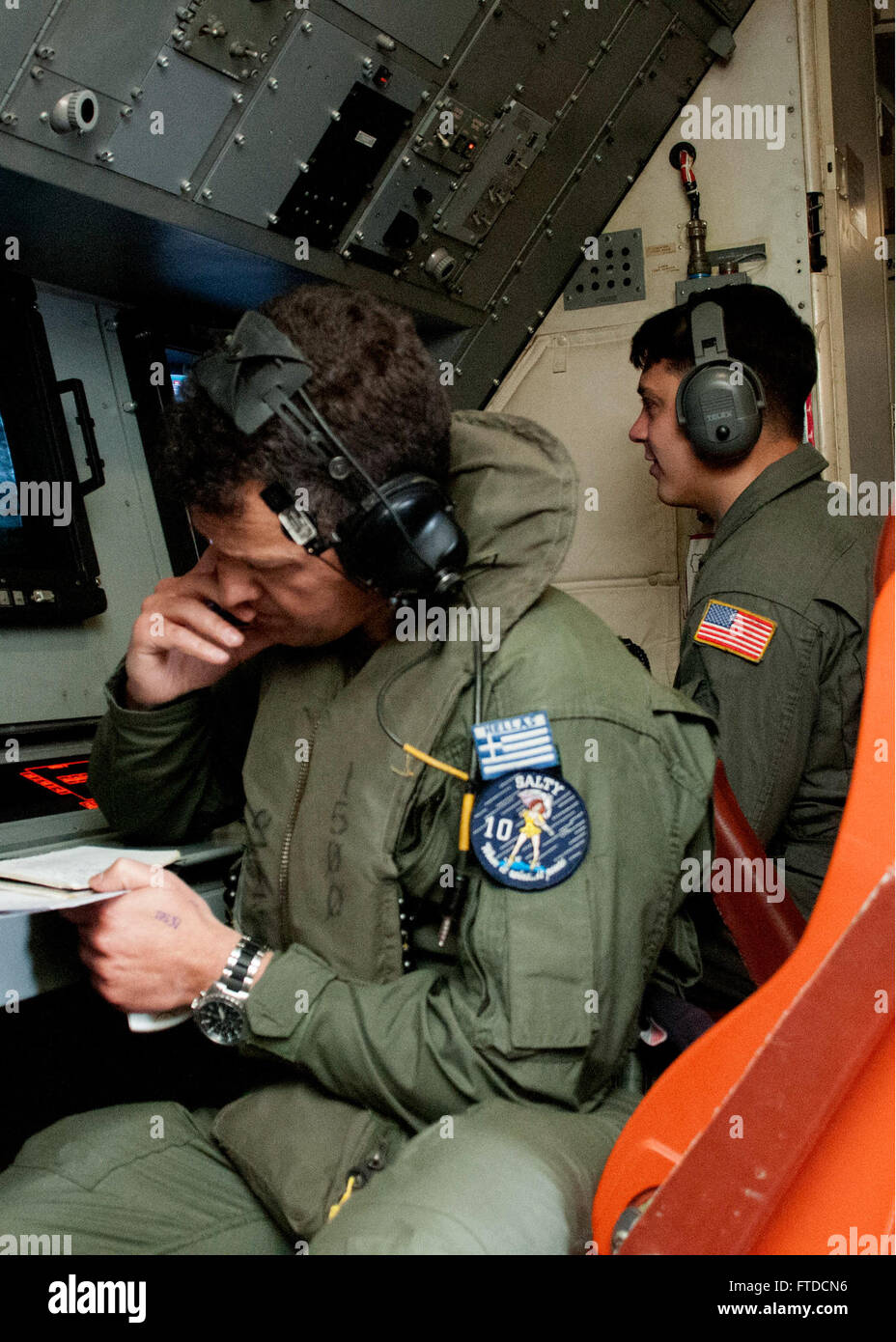 150520-N-YA681-204 MEDITERRANEAN SEA (May 20, 2015) Hellenic Air Force Lt. Cmdr. Kyriakos Koympis, left, conducts operations with Naval Air Crewman Operator 3rd Class Joseph Gallegos, a member of Patrol Squadron 47, aboard a P3-C Orion aircraft during Exercise Phoenix Express 2015, May 20.. Phoenix Express 2015, sponsored and facilitated by U.S. Africa Command, is designed to improve regional cooperation, maritime domain awareness, information-sharing practices, and tactical interdiction expertise to counter sea-based illicit activity in the region.  (U.S. Navy photo by Mass Communication Spec Stock Photo