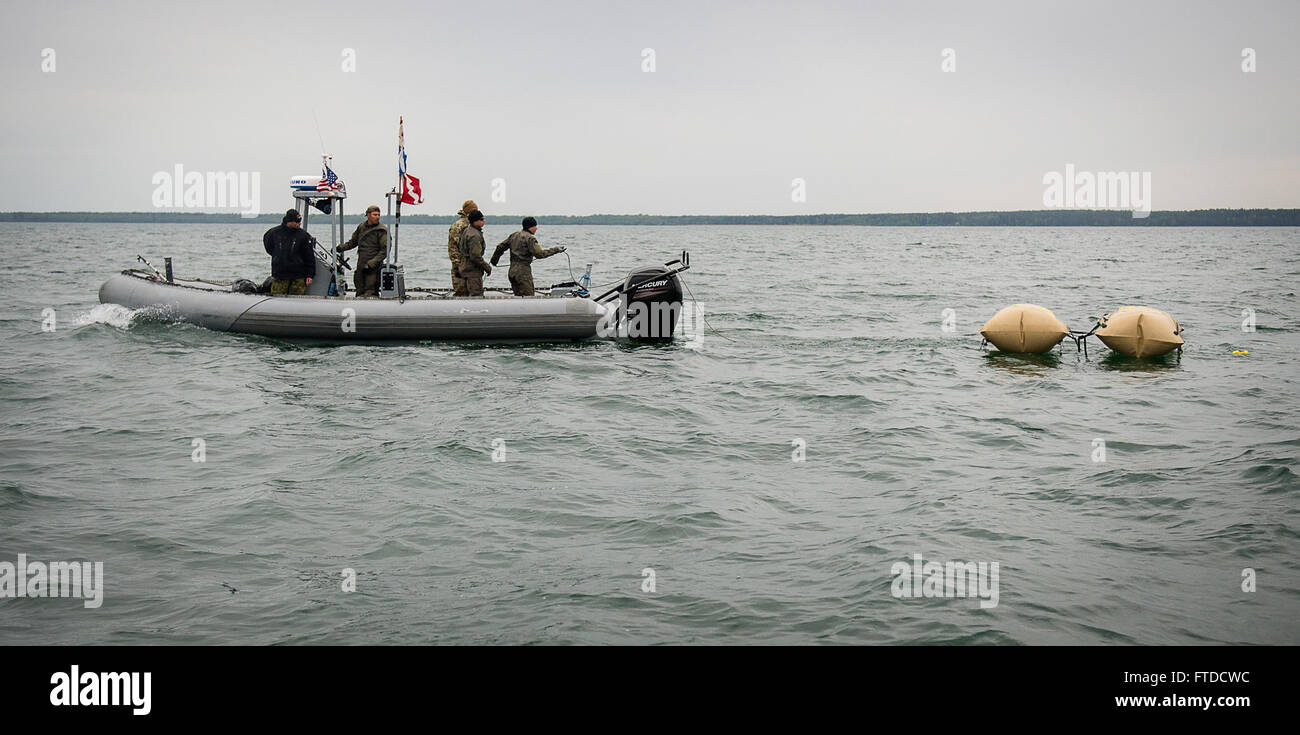 150526-N-RA981-086 BALTIC SEA (May 26, 2015) Members of Explosive Ordnance Disposal Mobile Unit (EODMU) 8, along with Estonia Explosive Ordance Dispoal team members, deploy enclosed flotation bags in order to tow a World War II-era German Bottom-Mine (LMB) as part of mine countermeasure operations in the Baltic Sea off the coast of Estonia, May 26,  during Exercise Open Spirit 2015. EODMU 8 is working in conjunction with EOD teams from Estonia, Germany, Latvia, Lithuania, Poland and Sweden to dispose of unexploded ordnance originating from World War II. (U.S. Navy photo by Mass Communication S Stock Photo
