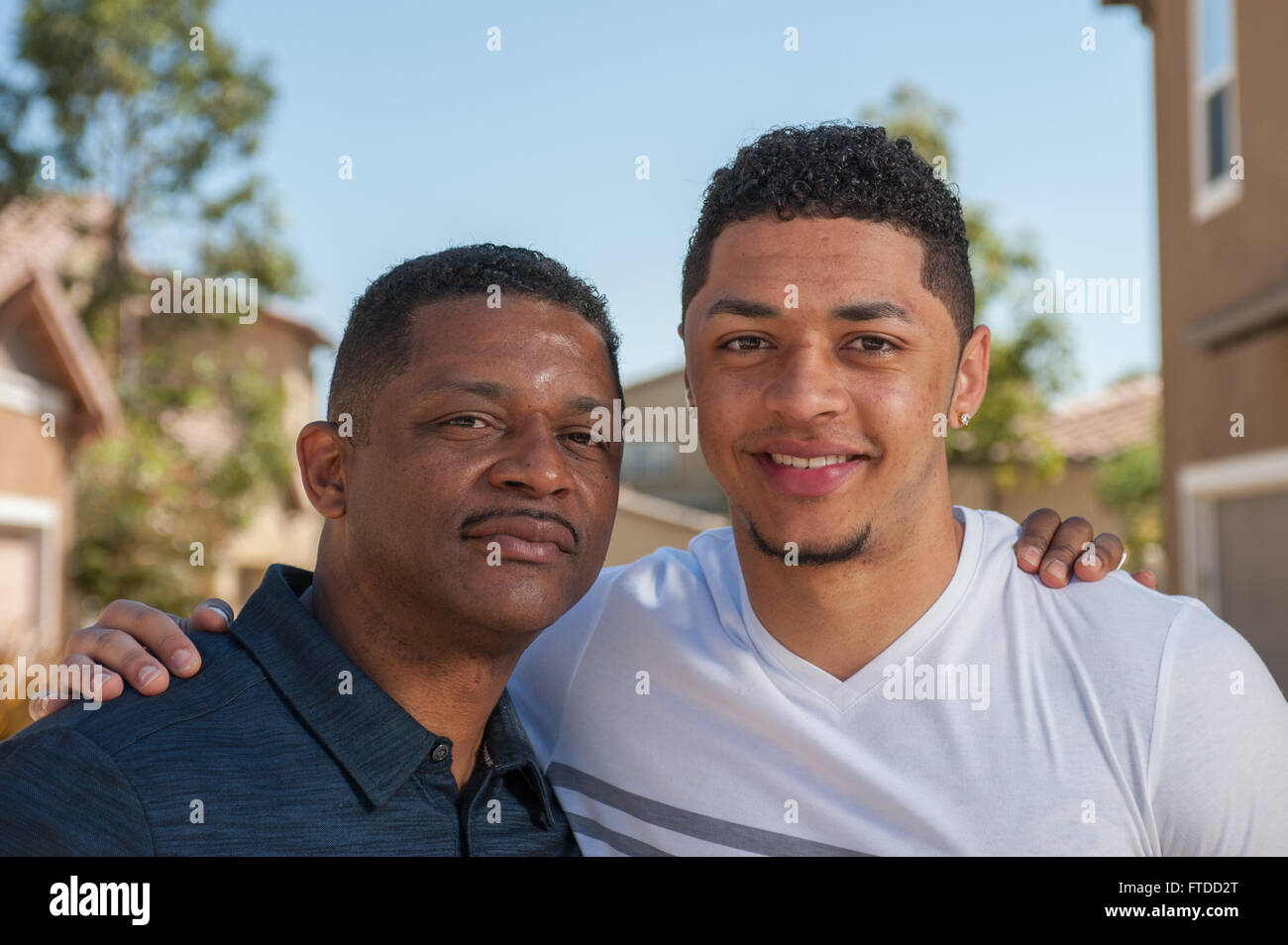 Happy mixed ethnic family father with his son posed in backyard Stock