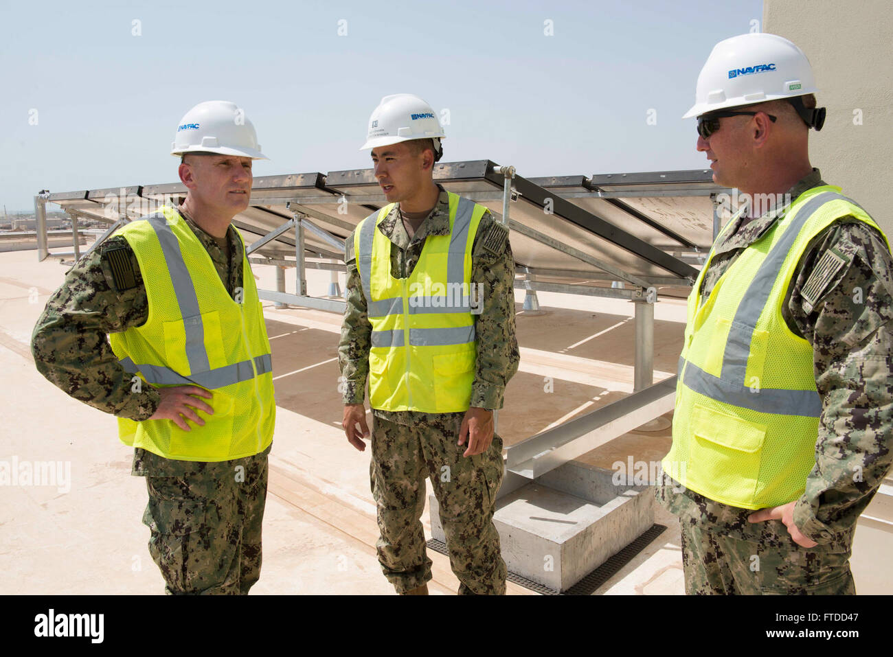 150603-N-OX801-138 CAMP LEMONNIER, Djibouti (June 3, 2015) Naval Forces Europe-Africa Fleet Master Chief Steven Giordano, left, tours solar water heating systems on a Camp Lemonnier  barracks under construction with Lt. Michael Yoshihara, second from left, and Senior Chief Construction Mechanic Jamie Warwick during a visit to Camp Lemonnier, Djibouti, Africa, June 3, 2015. Giordano's visit to Camp Lemonnier and Combined Joint Task Force-Horn of Africa locations served to better understand the commands' quality of work and quality of life, as well as recognizing exemplary Sailors within each co Stock Photo