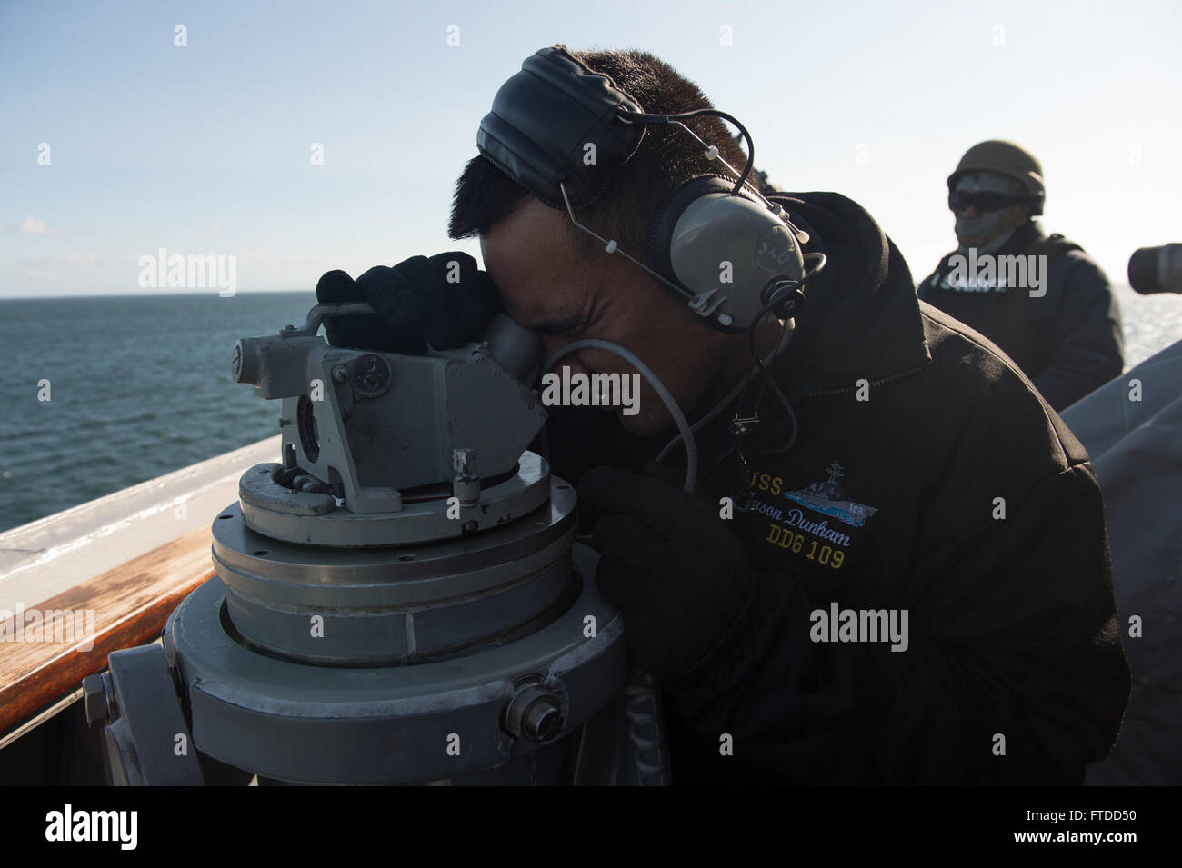 150604-N-ZE250-043 GDYNIA, Poland (June 4, 2015) Quartermaster 2nd Class Francis Mengote, from San Diego uses a telescopic alidade to take bearings aboard USS Jason Dunham (DDG 109) while pulling into port in Gdynia, Poland June 4, 2015. Jason Dunham, an Arleigh Burke-class guided-missile destroyer, homeported in Norfolk, is participating in BALTOPS 2015. BALTOPS is an annually recurring multinational exercise designed to enhance flexibility and interoperability, as well as demonstrate resolve of allied and partner forces to defend the Baltic region. (U.S. Navy photo by Mass Communication Spec Stock Photo