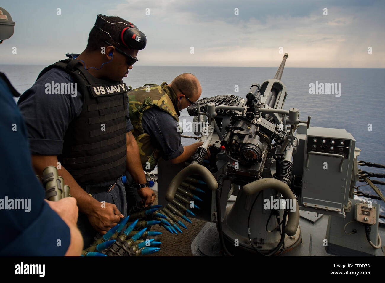 150606-N-FQ994-083 MEDITERRANEAN SEA (June 6, 2015) Gunner's Mate 3rd Class Alex Scott, from Blue Bell, Pennsylvania, left, and Sonar Technician (Geographical) 2nd Class Stephen Burnett, from Spartanburg, South Carolina, reload the Mark34 25 mm chaingun aboard USS Ross (DDG 71) during a crew served weapons shooting exercise June 6, 2015. Ross, an Arleigh Burke-class guided-missile destroyer USS Ross (DDG 71), forward-deployed to Rota, Spain, is conducting naval operations in the U.S. 6th Fleet area of operations in support of U.S. national security interests in Europe.  (U.S. Navy photo by Mas Stock Photo