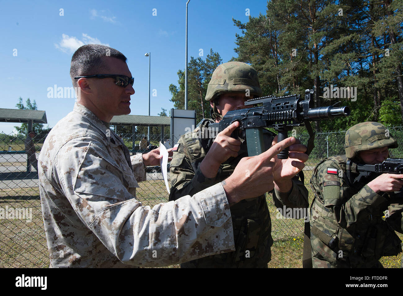 150611-N-AZ513-024 USTKA, Poland (June 11, 2015) U.S. Marine Sgt. Brett Sayre, assigned to Fleet Anti-terrorism Security Team Europe, (left) teaches to infantry men of Poland’s 1st Mechanized Battalion, how to properly fire from a combat stance during exercise Baltic Operations (BALTOPS) 2015. BALTOPS is an annual multinational exercise designed to enhance flexibility and interoperability, as well as demonstrate resolve among allied and partner forces to defend the Baltic region. (US Navy photo by Mass Communication Specialist 2nd Class John Callahan/Released) Stock Photo