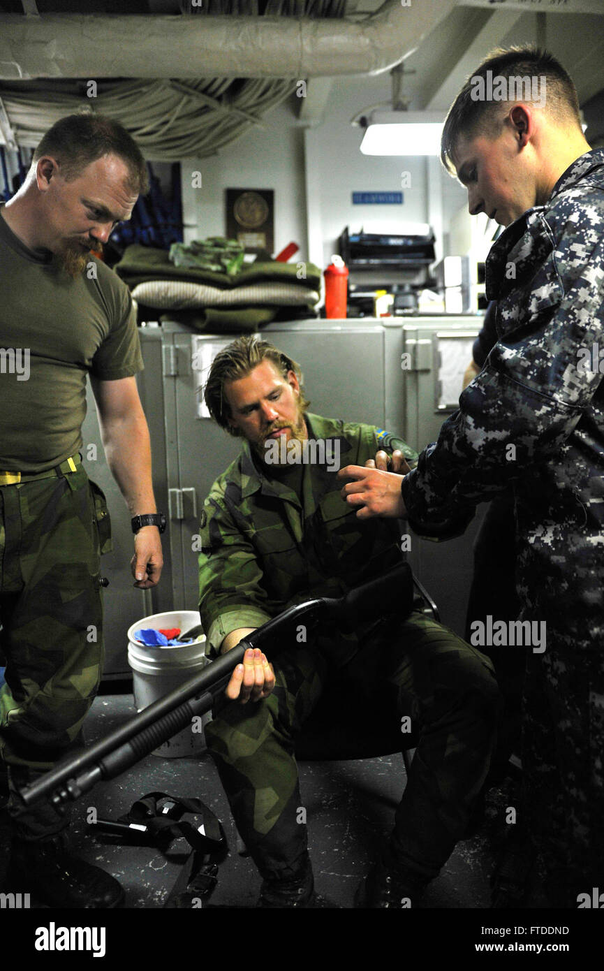 BALTIC SEA (June 13, 2015) Gunner's Mate seaman Ryan Archer, originally from Topeka, Kansas, intructs two Swedish marines about the rounds of an M500 shotgun in the ships armory (June 13, 2015). San Antonio, home ported in Norfolk, Virginia, is conducting Baltic Operations, (BALTOPS) in the 6th Fleet area of operations to promote flexibility and interoperability between allied countries in the North Atlantic Treaty Orginization. Stock Photo