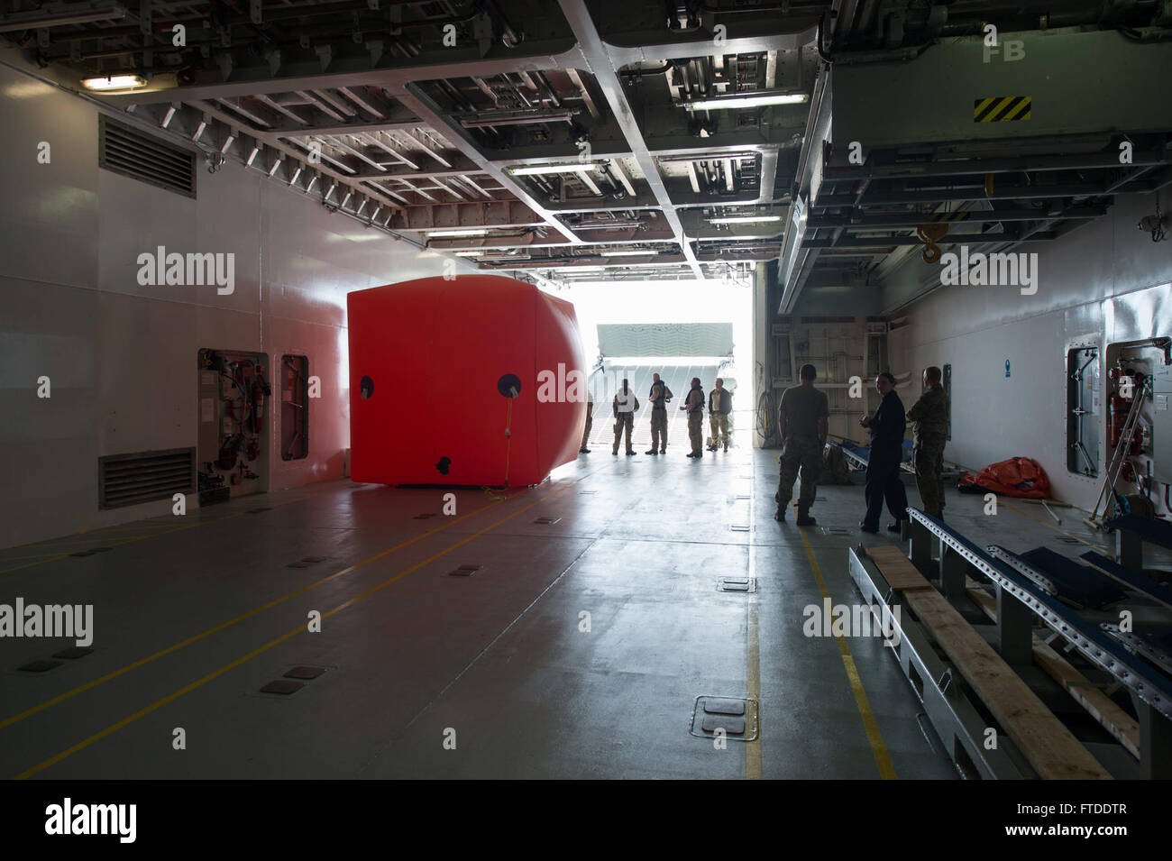 150617-N-ZE250-030 BALTIC SEA (June 17, 2015) Sailors from USS Jason Dunham (DDG 109) watch as Danish sailors prepare to lower an inflatable target into the water from the hangar bay of Danish Navy Frigate HDMS Absalon (L16) prior to a live fire exercise June 17, 2015. Jason Dunham, an Arleigh Burke-class guided-missile destroyer homeported in Norfolk, is participating in exercise Baltic Operations (BALTOPS) 2015. BALTOPS is an annually recurring multinational exercise designed to enhance flexibility and interoperability, as well as demonstrate resolve of Allied and partner forces to defend th Stock Photo