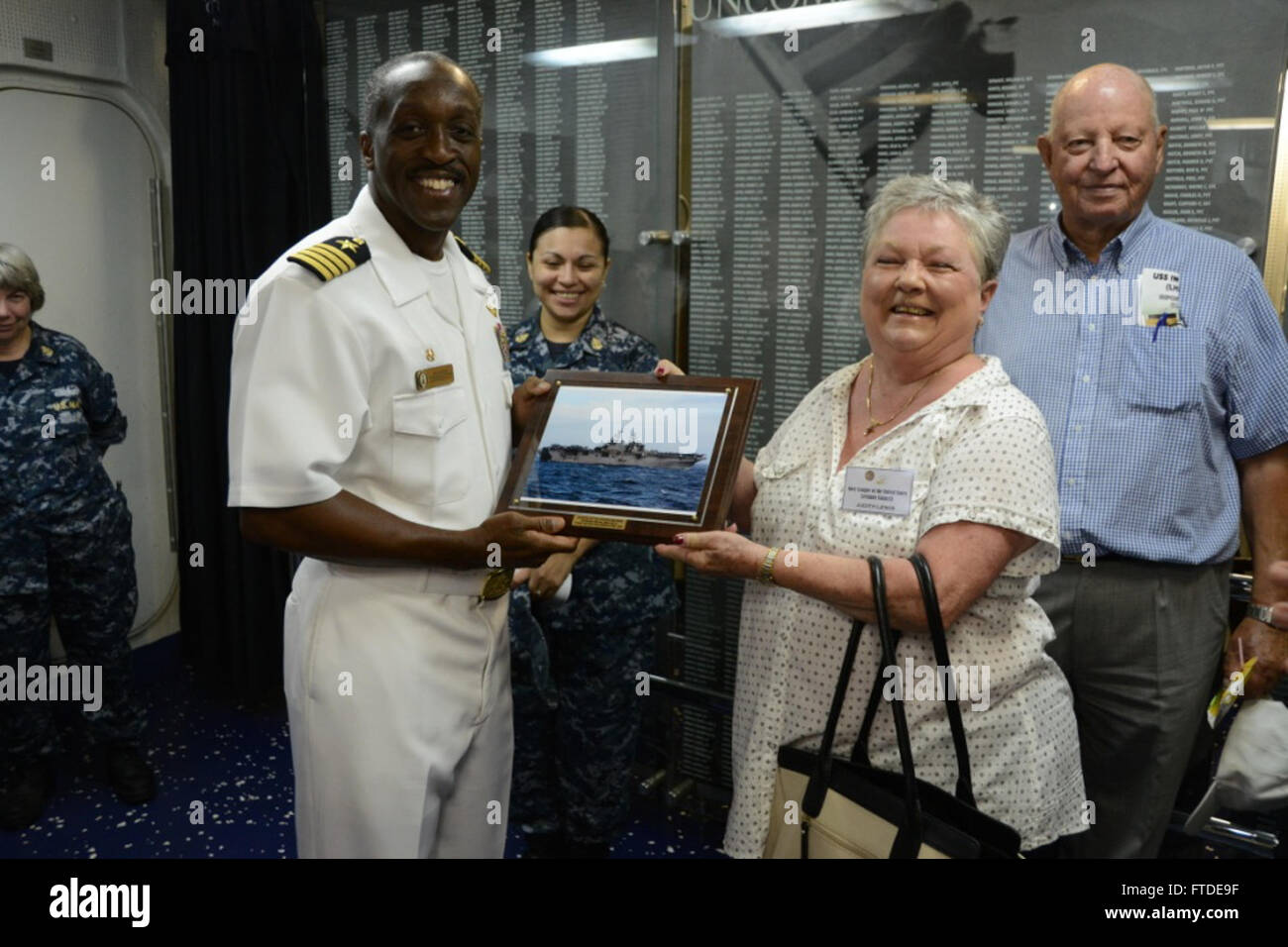 150629-N-JA759-190 VALENCIA, Spain (June 29, 2015) Capt. Dana Gordon, commanding officer of the amphibious assault ship USS Iwo Jima (LHD 7), presents a gift of thanks to Judith Lewis, Chapter President of the Navy League of the United States, after a tour aboard USS Iwo Jima in Valencia, Spian, June 29, 2015. USS Iwo Jima is the flagship for the Iwo Jima Amphibious Ready Group/24th Marine Expeditionary Unit and is conducting naval operations in the U. S. 6th Fleet area of operations in support of U. S. national security interests in Europe. (Mass Communication Specialist 1st Class Barry Abbot Stock Photo