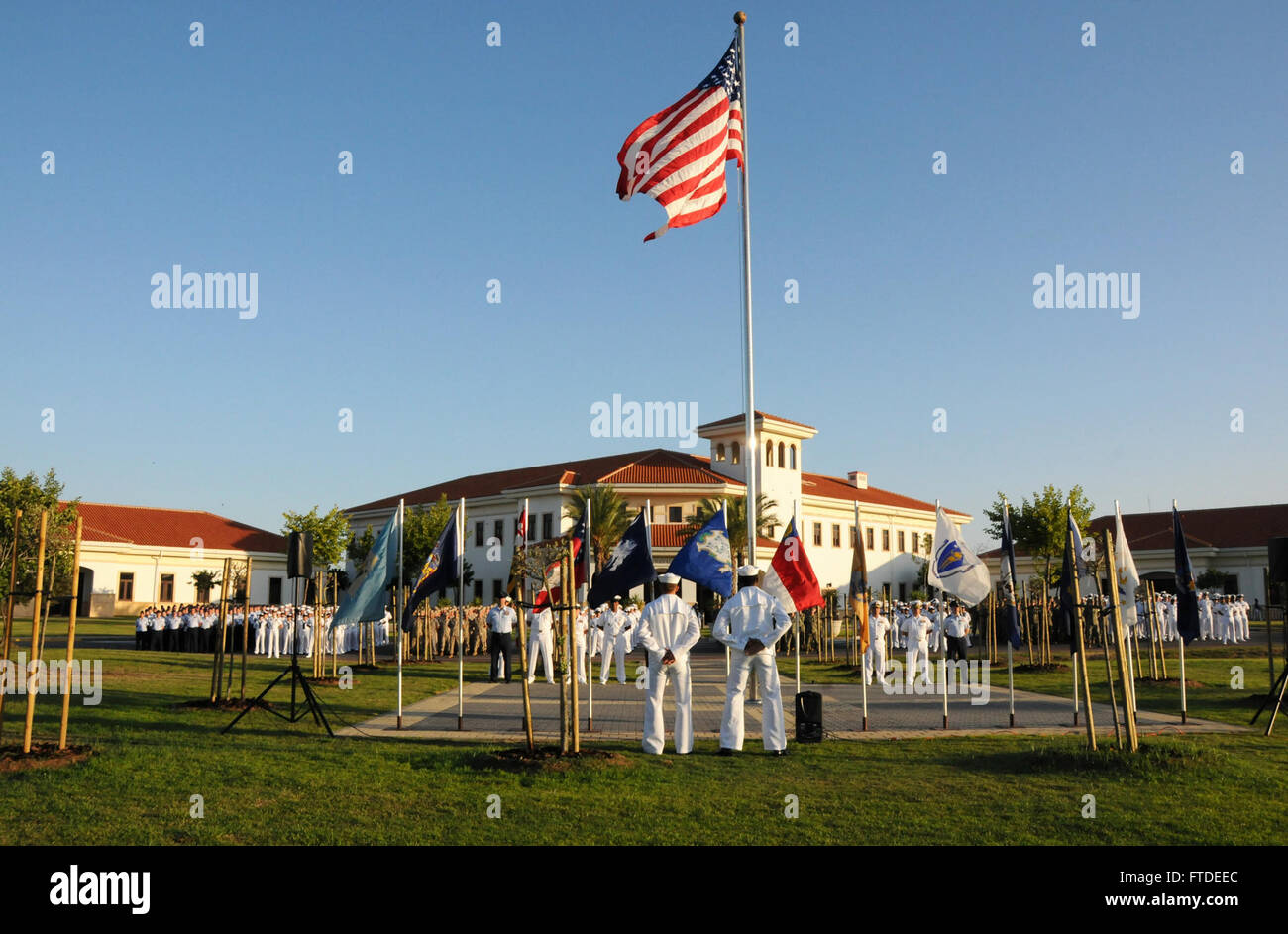150702-N-UI568-143 NAVAL STATION ROTA, Spain (July 2, 2015) - Service members assigned to Commander, U.S. Naval Activities Spain stand at attention during the annual flag-raising ceremony Naval Station Rota, Spain, July 2.  While raising the flag is a daily occurrence on most U.S. military installations around the world, Naval Station Rota is only permitted to fly the American flag with special permission from the base’s Spanish admiral in chief in accordance with the Agreement on Defense Cooperation.  (U.S. Navy photo by Morgan Over/Released) Stock Photo
