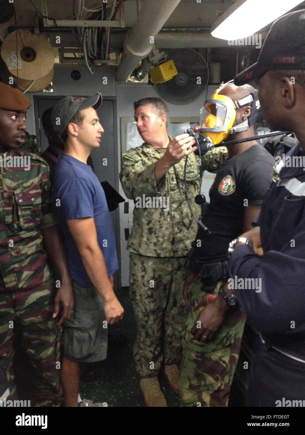 150704-N-ZZ999-016 ABIDJAN, Cote d’ Ivoire (July 4, 2015) Senior Chief Navy Diver Donald Schappert and Navy Diver 2nd Class Octavio Alvarez, Sailors assigned to Mobile Diving and Salvage Unit (MDSU) 2-4, demonstrate the use of a full face mask for SCUBA aboard the Military Sealift Command rescue and salvage ship USNS GRASP (T-ARS 51) during a diving exercise in support of theater security cooperation in Abidjan, Cote d’Ivoire, July 4, 2015. U.S. 6th Fleet, headquartered in Naples, Italy, conducts the full spectrum of joint and naval operations, often in concert with allied, joint, and interage Stock Photo