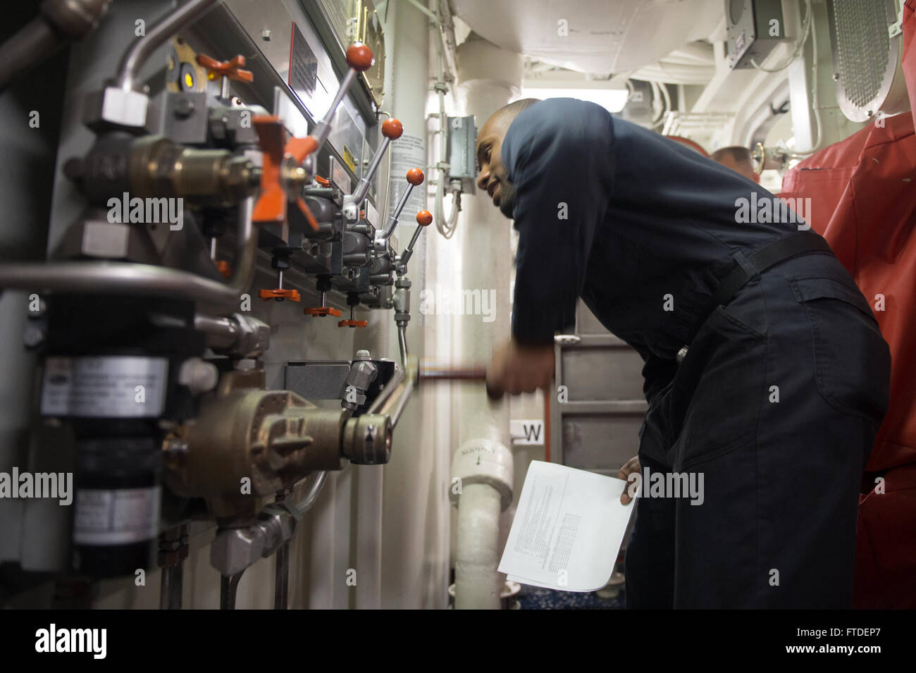 150710-N-ZE250-049 BALTIC SEA (July 10, 2015) Damage Control Fireman Blayze Artis performs maintenance on a miscellaneous vacuum hydraulic console aboard USS Jason Dunham (DDG 109) July 10, 2015. Jason Dunham, an Arleigh Burke-class guided-missile destroyer homeported in Norfolk, is conducting naval operations in the U.S. 6th Fleet area of operations in support of U.S. national security interests in Europe. (U.S. Navy photo by Mass Communication Specialist 3rd Class Weston Jones/Released) Stock Photo