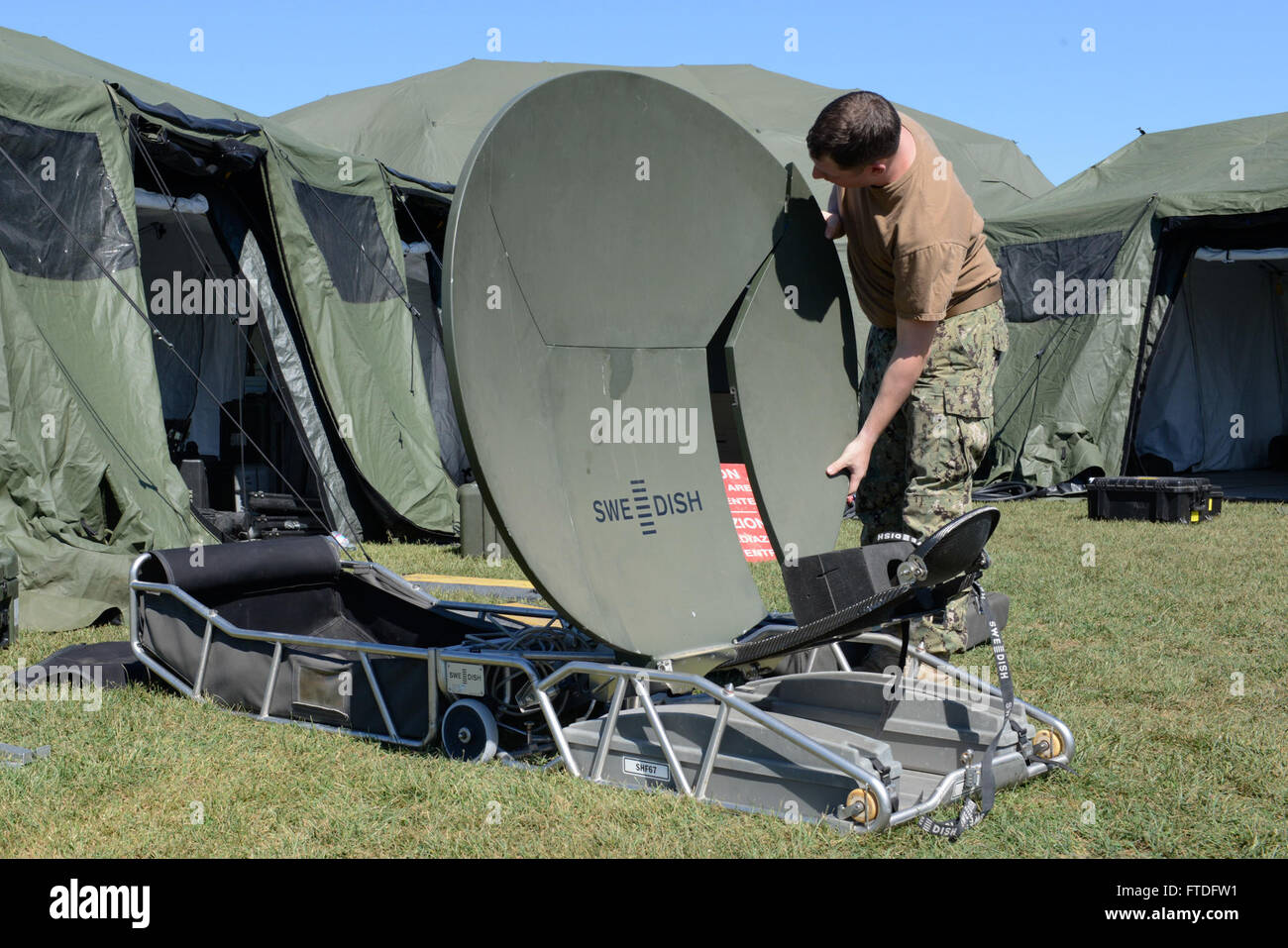 150921-N-UE250-028 GRICIGNANO, Italy (Sept. 21, 2015) Electronics Technician 1st Class Nicholas Cummings, assigned to Commander, Naval Forces Europe Det. Maritime Ashore Support Team (MAST), assembles a satellite dish at a mobile command center on U.S. Naval Support Activity Naples, Italy Sept. 21, 2015. MAST is currently conducting a Continuity of Operations Planning and crisis management field training exercise. (U.S. Navy photo by Mass Communication Specialist 2nd Class Corey Hensley/Released) Stock Photo