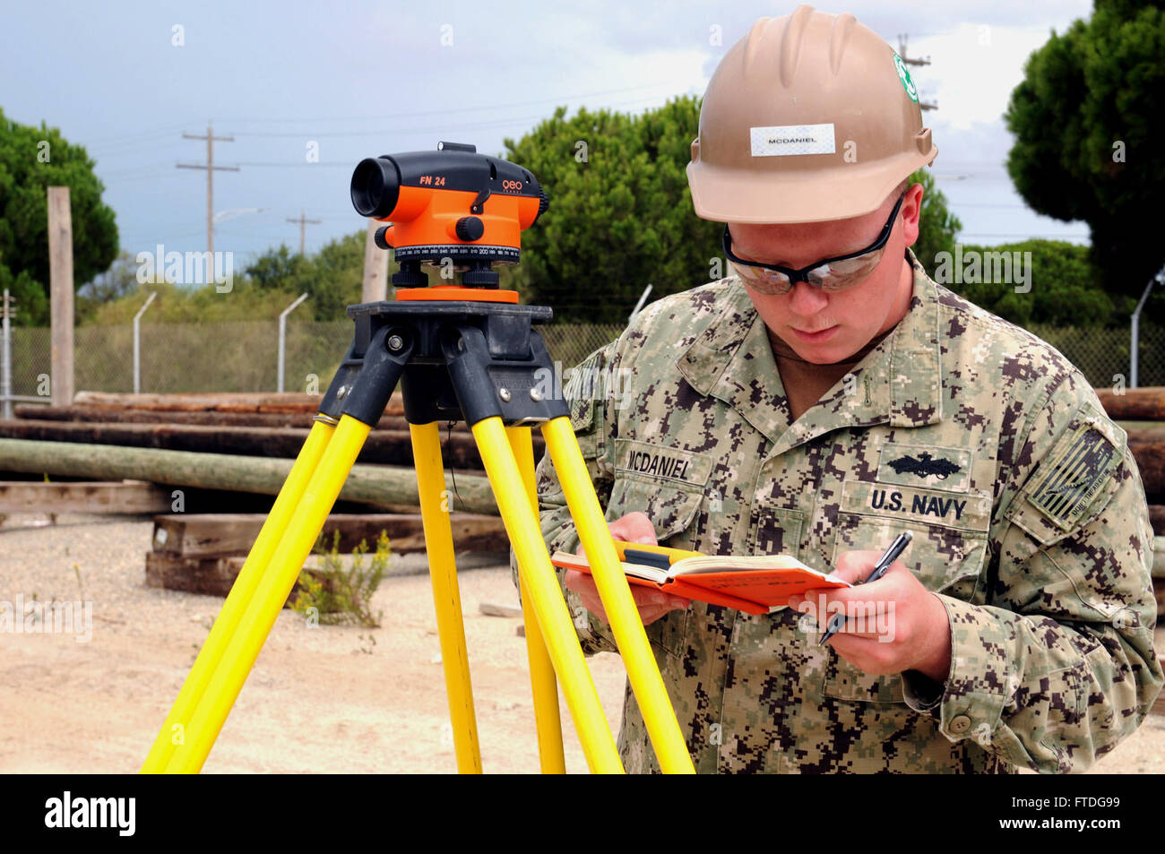 151011-N-SD965-039 ROTA, Spain (Oct. 11, 2015) Engineering Aide Constructionman Dylan McDaniel, from El Paso, Illinois, assigned to Naval Mobile Construction Battalion 1, calculates elevation for a trench being dug for utilities pipes on Naval Station Rota, Spain, Oct. 11, 2015. The trench is for a shipboard electronic systems evaluation facilities project which will provide test and evaluation services to U.S. Navy, U.S. Coast Guard and Military Sealift Command activities as well as allied foreign navies. (U.S. Navy photo by Mass Communication Specialist 1st Class Brannon Deugan/Released) Stock Photo