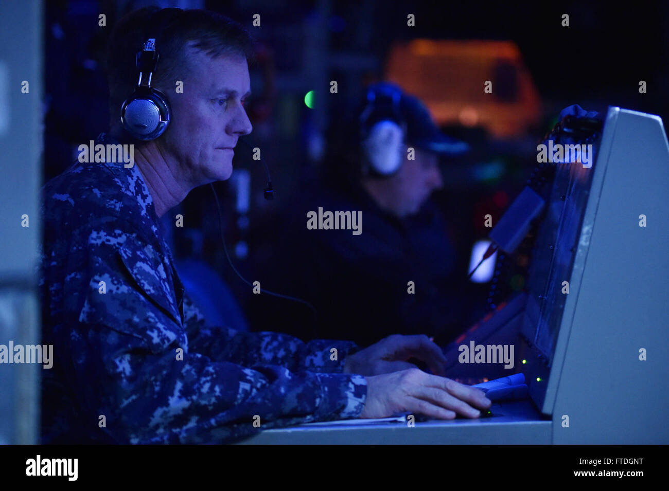 151020-N-XT273-195 ATLANTIC OCEAN (Oct. 20, 2015) Capt. Jeffrey Wolstenholme commodore of Task Force Sixty Four (CTF 64), monitors Hebrides Range communication in the combat information center during the Maritime Theater Missile Defense (MTMD) Forum's at Sea Demonstration (ASD-15) countdown aboard the Arleigh Burke-class destroyer USS Ross (DDG 71).  Ships from Canada, France, Italy, The Netherlands, Norway, Spain, United Kingdom, and the United States tracked and destroyed target ballistic and anti-ship cruise missiles during the demonstration's six-live fire scenarios. Germany provided perso Stock Photo