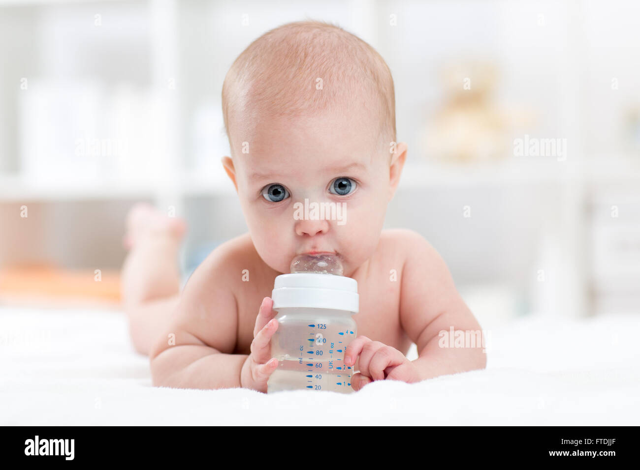 sweet baby holding bottle and drinking water Stock Photo Alamy