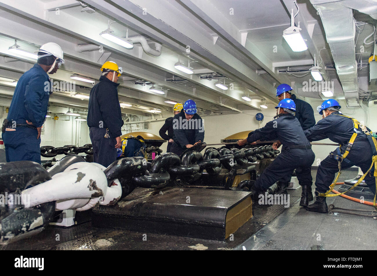 151209-N-NX690-032 SPLIT, CROATIA (Dec. 9, 2015) Sailors from Deck department attach a pelican hook to an anchor chain in the fo'c'sle aboard aircraft carrier USS Harry S. Truman (CVN 75). Harry S. Truman Carrier Strike Group is conducting naval operations in the U.S. 6th Fleet area of operations in support of U.S. national security interests in Europe and Africa. (U.S. Navy photo by Mass Communication Specialist 3rd Class J. M. Tolbert/Released) Stock Photo