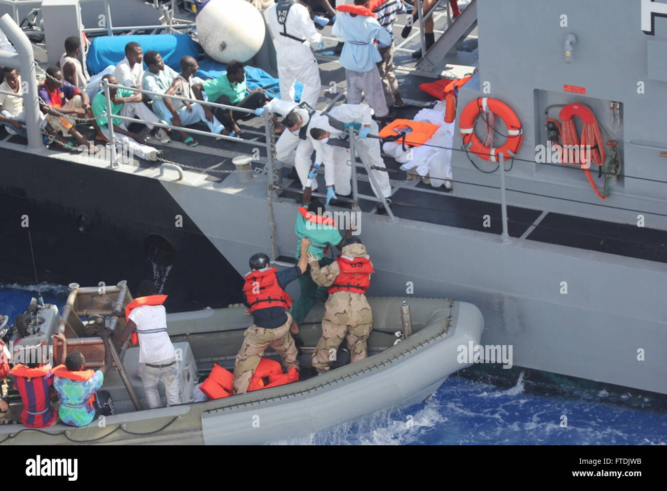 131017-N-ZZ999-008: MEDITERRANEAN SEA (Oct. 17, 2013) – Distressed persons are transferred from the amphibious transport dock ship USS San Antonio (LPD 17) to Armed Forces of Malta Offshore Patrol Vessel (P 52). San Antonio provided food, water, medical attention, and temporary shelter to the rescued. San Antonio rescued 128 men adrift in an inflatable raft after responding to a call by the Maltese Government. (U.S. Navy photo) Stock Photo