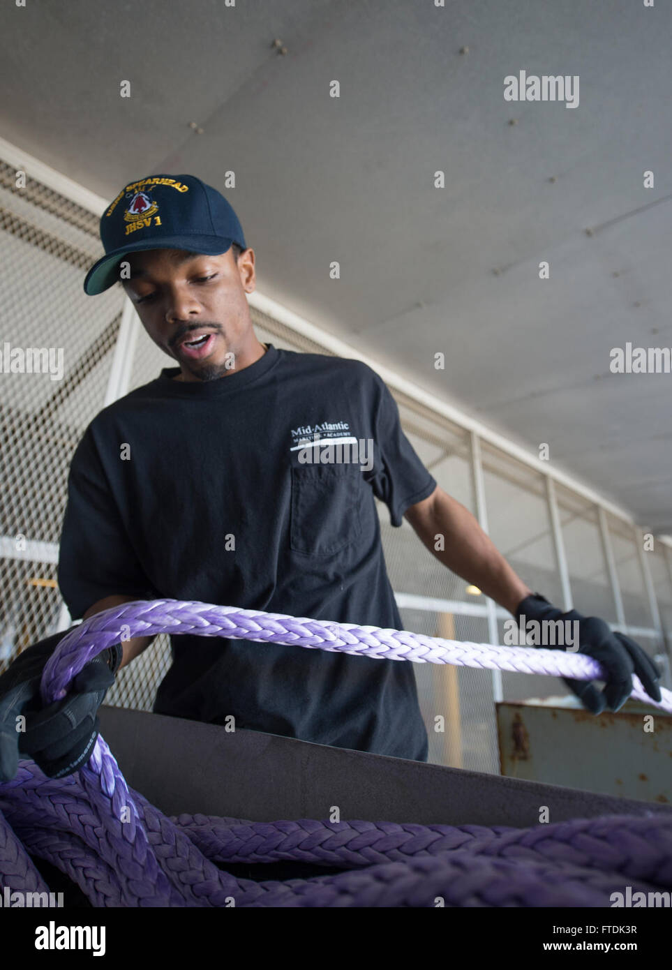 160104-N-WV703-096 ATLANTIC OCEAN (Jan. 4, 2016) David Leader, a civil service mariner, stows new mooring line aboard USNS Spearhead (T-EPF 1) Jan. 4, 2015. The Military Sealift Command expeditionary fast transport vessel USNS Spearhead (T-EPF 1) is on a scheduled deployment to the U.S. 6th Fleet area of operations to support the international collaborative capacity-building program Africa Partnership Station. (U.S. Navy photo by Mass Communication Specialist 3rd Class Amy M. Ressler/Released) Stock Photo