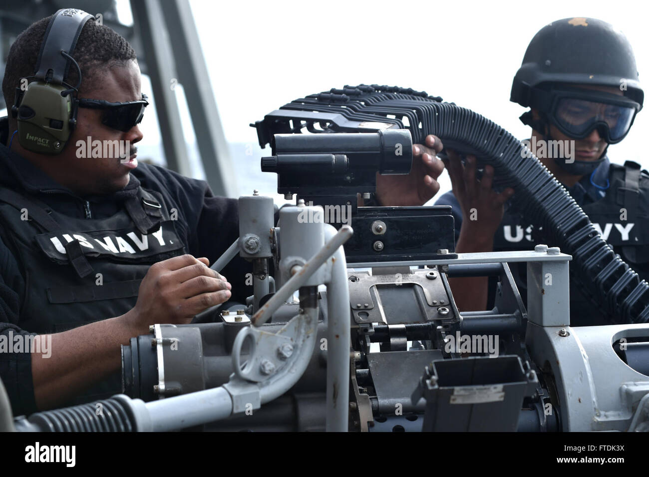 160104-N-XT273-183 MEDITERRANEAN SEA (Jan. 4, 2016) Gunner's Mate 2nd Class Alex Scott and Gunner's Mate 3rd Class Joseph Martinez remove the feed shoot from a 25mm gun aboard USS Ross (DDG 71) after a live fire training exercise in the Mediterranean Sea Jan. 4, 2016. Ross, an Arleigh Burke-class guided-missile destroyer, forward deployed to Rota, Spain, is conducting a routine patrol in the U.S. 6th Fleet area of operations in support of U.S. national security interests in Europe. (U.S. Navy photo by Mass Communication Specialist 2nd Class Justin Stumberg/Released) Stock Photo