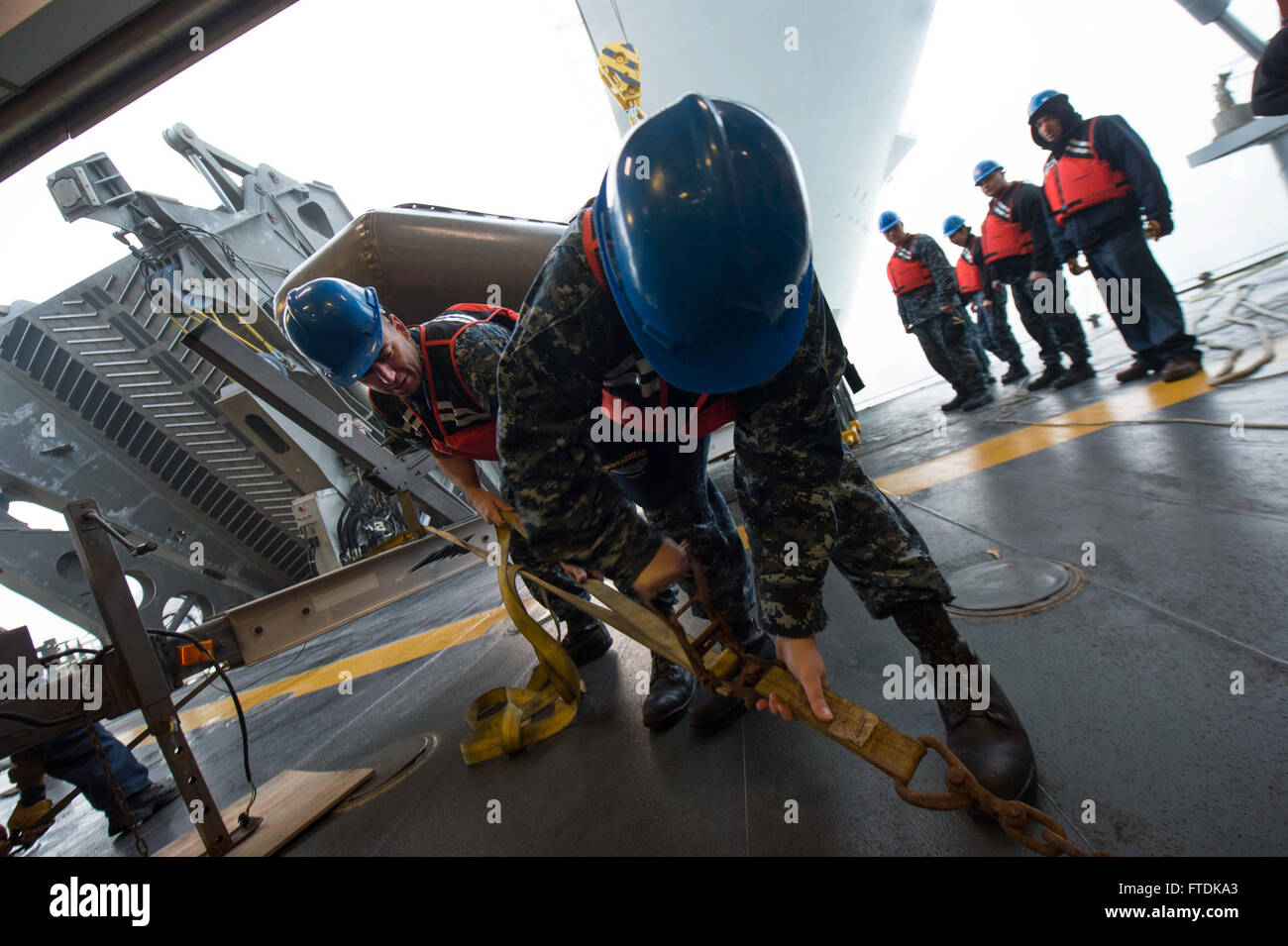 This U.S. Navy image from January 12, 2016, shows Boatswain's Mate 2nd Class Ryan Feeney and Engineman 3rd Class Sheila Allen securing a cargo strap on the USNS Spearhead (T-EPF 1) in Rota, Spain. The vessel is part of the Africa Partnership Station mission, supporting collaborative capacity-building in Africa. Stock Photo