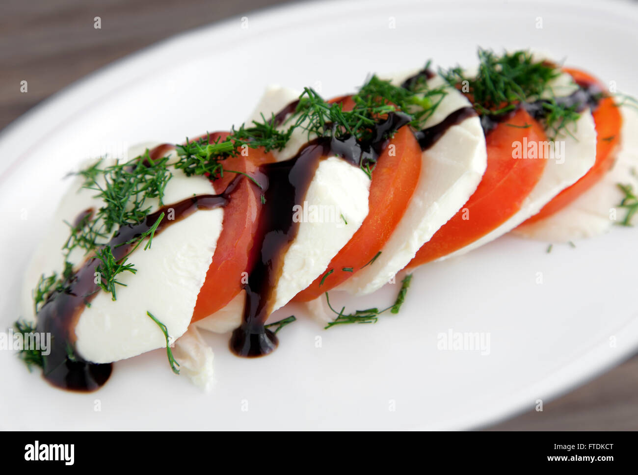 Italian Caprese Salad with a twist, adding dill and creamy Balsamic vinegar. Stock Photo