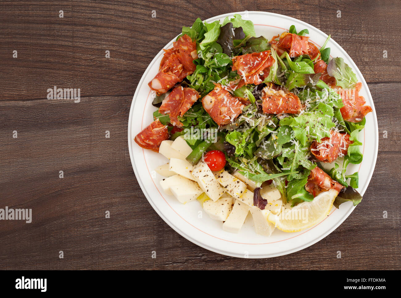 A plate of Italian salad with salami calabrese, cherry tomato