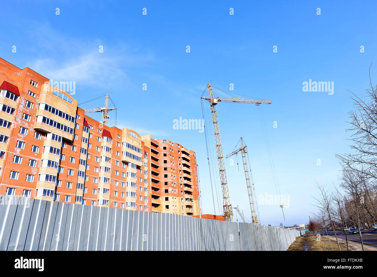 Crane and building construction site against blue sky. Stock Photo