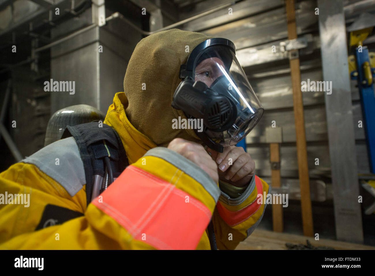 160205-N-WV703-119  ATLANTIC OCEAN (Feb. 05, 2016) - Boatswain's Mate Jimmie Connor, a civil service mariner, dons his personal protective gear during a firefighting drill aboard USNS Spearhead (T-EPF 1) Feb. 05, 2016. The Military Sealift Command expeditionary fast transport vessel USNS Spearhead is on a scheduled deployment in the U.S. 6th Fleet area of operations to support the international collaborative capacity-building program Africa Partnership Station. (U.S. Navy photo by Mass Communication Specialist 3rd Class Amy M. Ressler/Released) Stock Photo