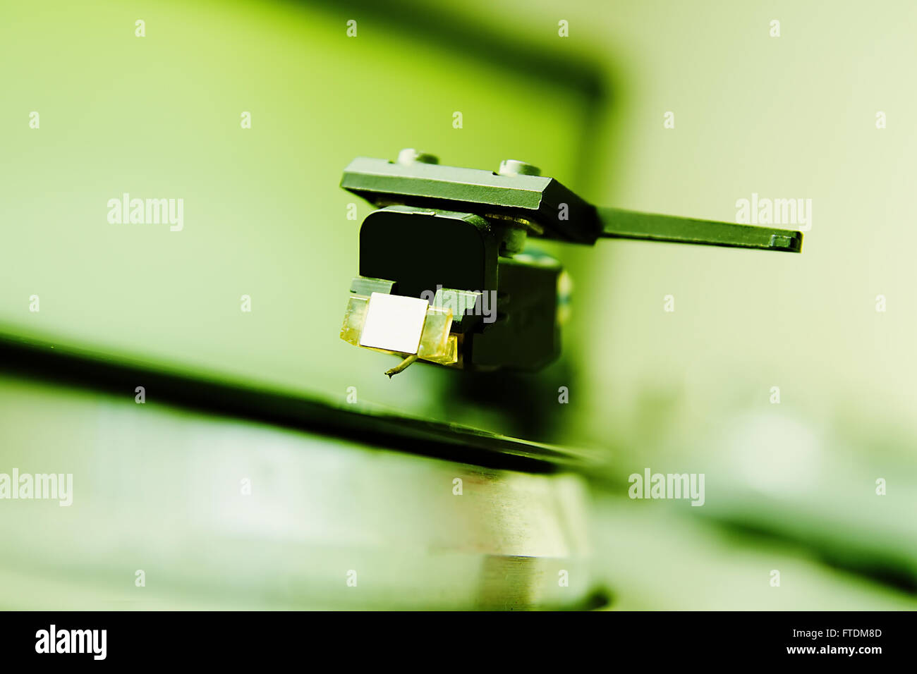 Turntable player with musical vinyl record. Useful for DJ, nightclub and retro theme. Saturated green color Stock Photo