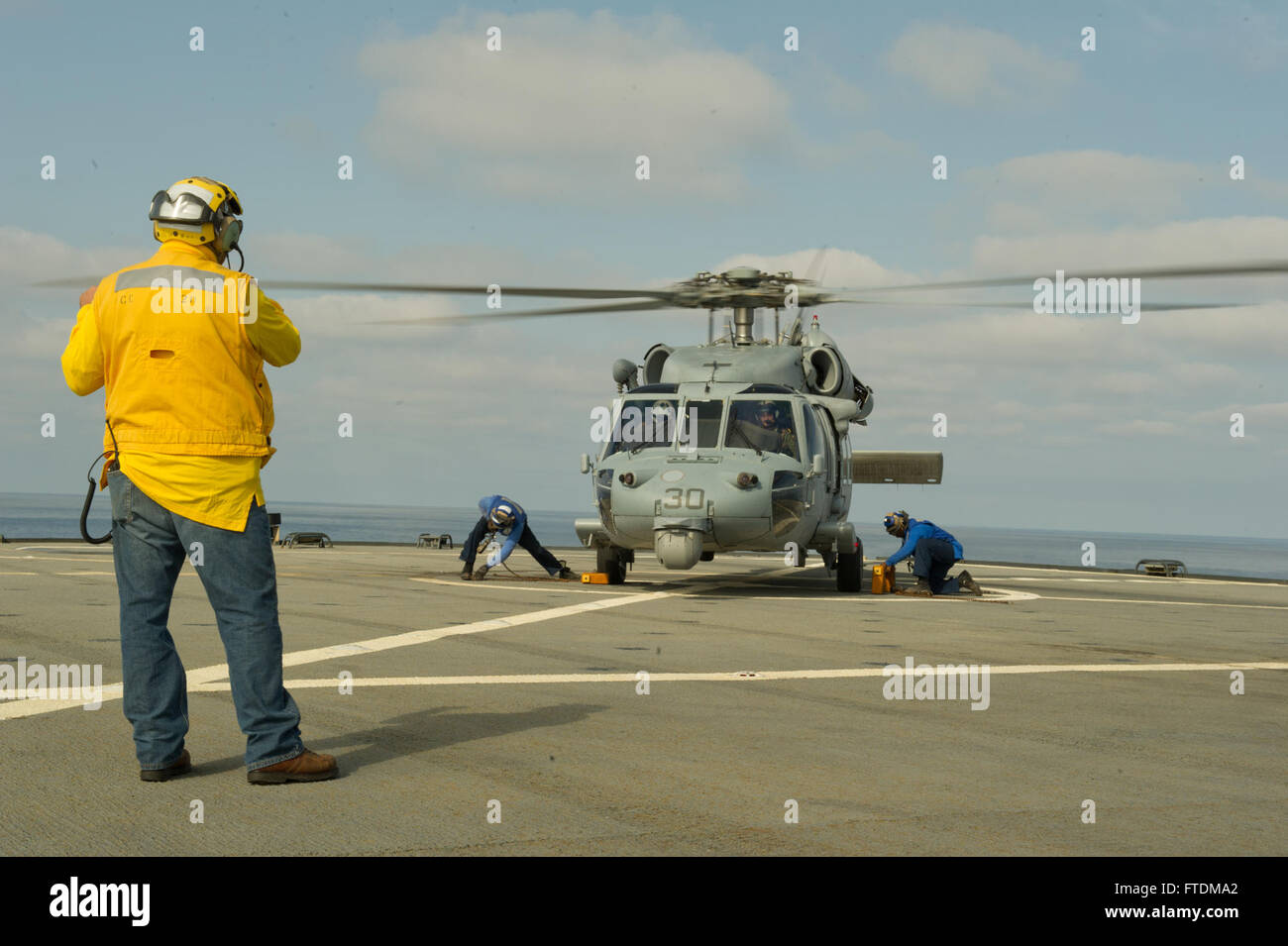 131022-N-UE250-111: MEDITERANEAN SEA (Oct. 22, 2013) – A Military Sealift Command civil service mariner signals to the pilots of an MH-60S Sea Hawk, from the Dragon Whales of Helicopter Sea Combat Squadron 28, on the flight deck of the U.S. 6th Fleet flagship USS Mount Whitney (LCC 20).  Mount Whitney, homeported in Gaeta, Italy, is currently underway conducting maritime security operations and theater security cooperation efforts in the U.S. 6th Fleet area of operations. (U.S. Navy photo by Mass Communication Specialist 2nd Class Corey Hensley) Stock Photo