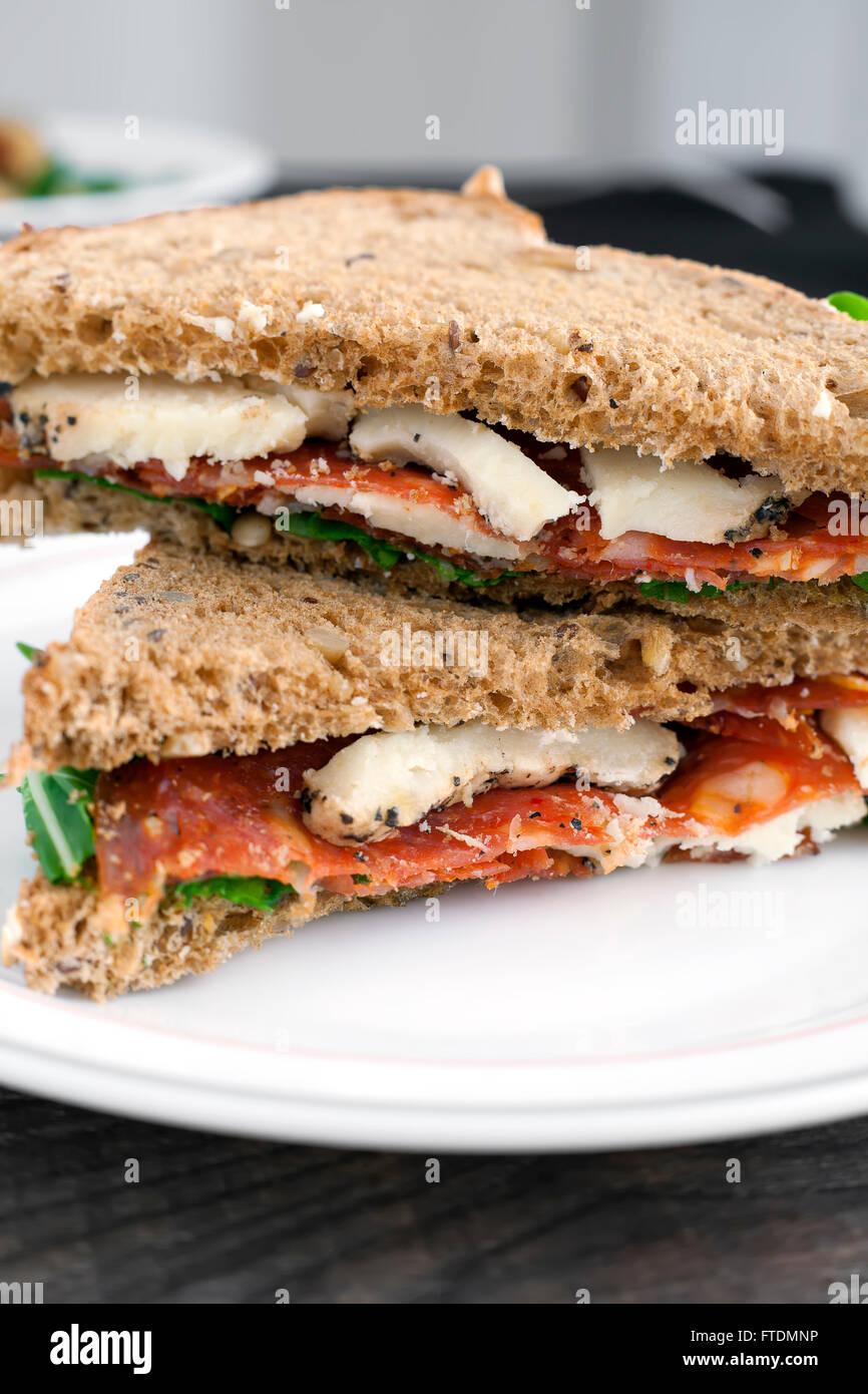 Italian salami and sheep cheese sandwich with brown bread. Stock Photo