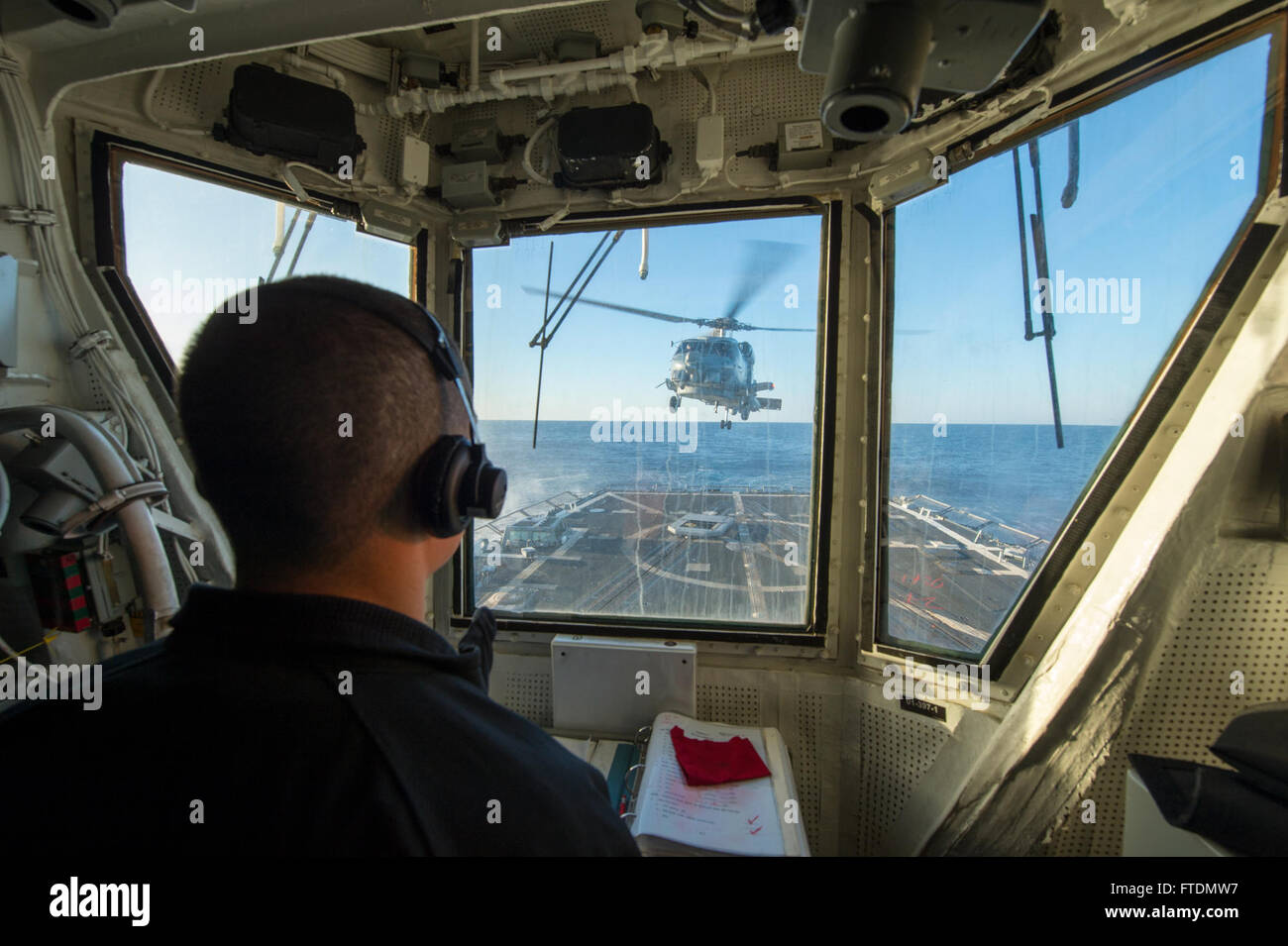 131023-N-NU634-068: MEDITERRANEAN SEA (Oct. 23, 2013) – Lt.j.g. Shaun McGahan watches as an SH-60R Seahawk prepares to land on the flight deck aboard the Arleigh Burke-class guided missile destroyer USS Gravely (DDG 107). Gravely, homeported in Norfolk, Va., is on a scheduled deployment supporting maritime security operations and theater security cooperation efforts in the 6th Fleet area of operations. (U.S. Navy photo by Mass Communication Specialist 3rd Class Darien G. Kenney/Released) Stock Photo