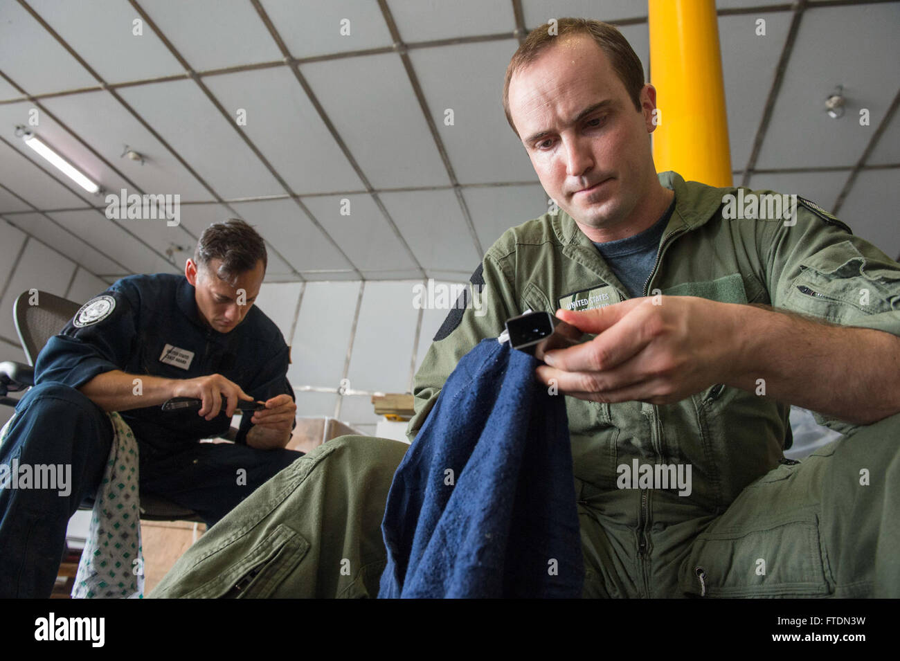 160306-N-QF605-023 GULF OF GUINEA (March 6, 2016) Machinery Technician 2nd Class Paul Avella, left, and Maritime Enforcement Specialist 1st Class Glenn Hyzak, U.S. Coast Guard Law Enforcement Detachment members, perform weapons maintenance aboard USNS Spearhead (T-EPF 1), March 6, 2016. The Military Sealift Command expeditionary fast transport vessel USNS Spearhead is on a scheduled deployment to the U.S. 6th Fleet area of operations to support the international collaborative capacity-building program Africa Partnership Station. (U.S. Navy photo by Mass Communication Specialist 1st Class Amand Stock Photo