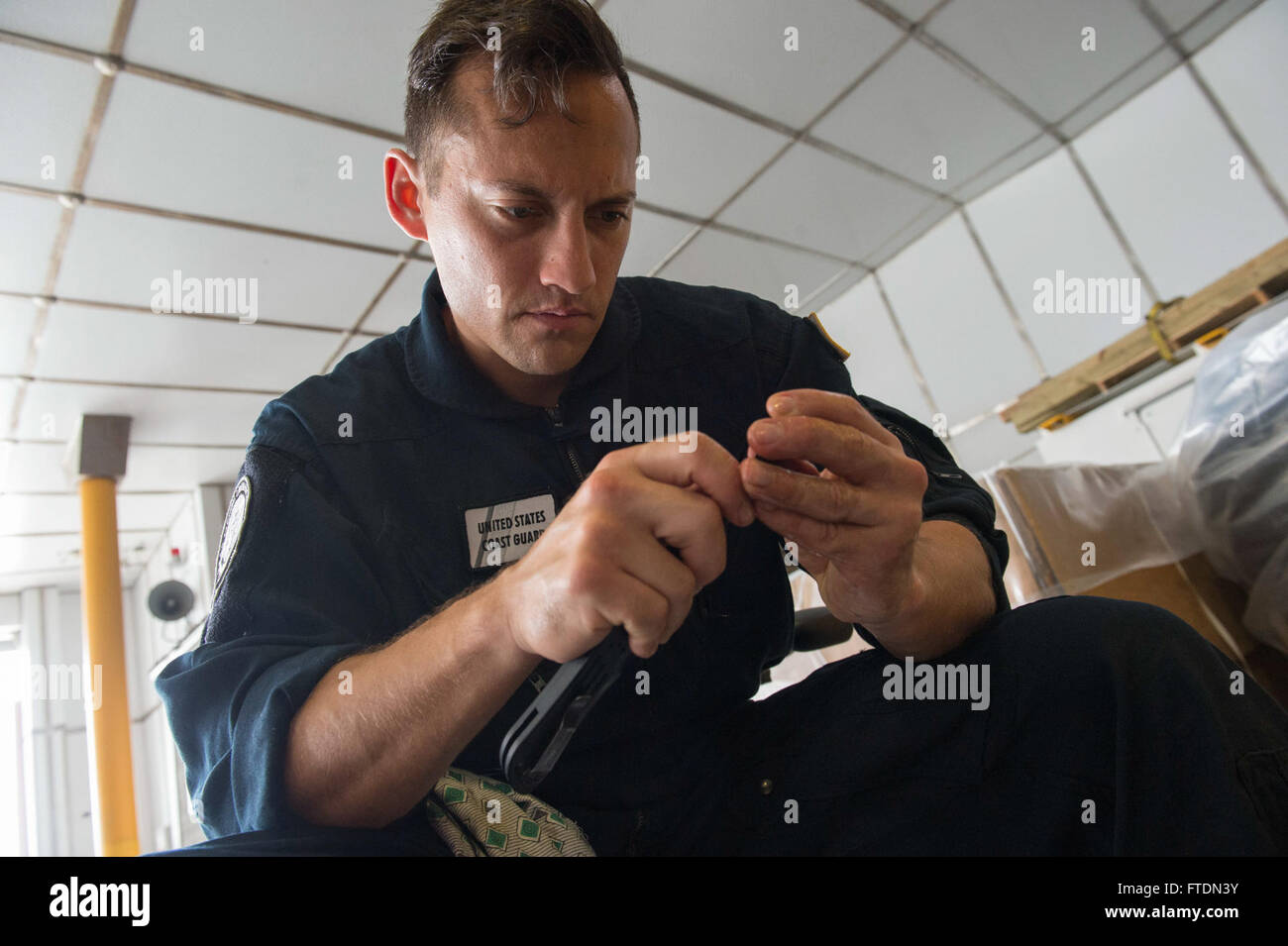 160306-N-QF605-026 GULF OF GUINEA (March 6, 2016) Machinery Technician 2nd Class Paul Avella, a U.S. Coast Guard Law Enforcement Detachment member, performs weapons maintenance aboard USNS Spearhead (T-EPF 1), March 6, 2016. The Military Sealift Command expeditionary fast transport vessel USNS Spearhead is on a scheduled deployment to the U.S. 6th Fleet area of operations to support the international collaborative capacity-building program Africa Partnership Station. (U.S. Navy photo by Mass Communication Specialist 1st Class Amanda Dunford/Released) Stock Photo