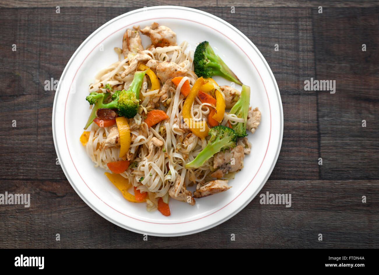 Fried chicken noodles with vegetables broccoli, cabbage, paprika and carrots. Stock Photo