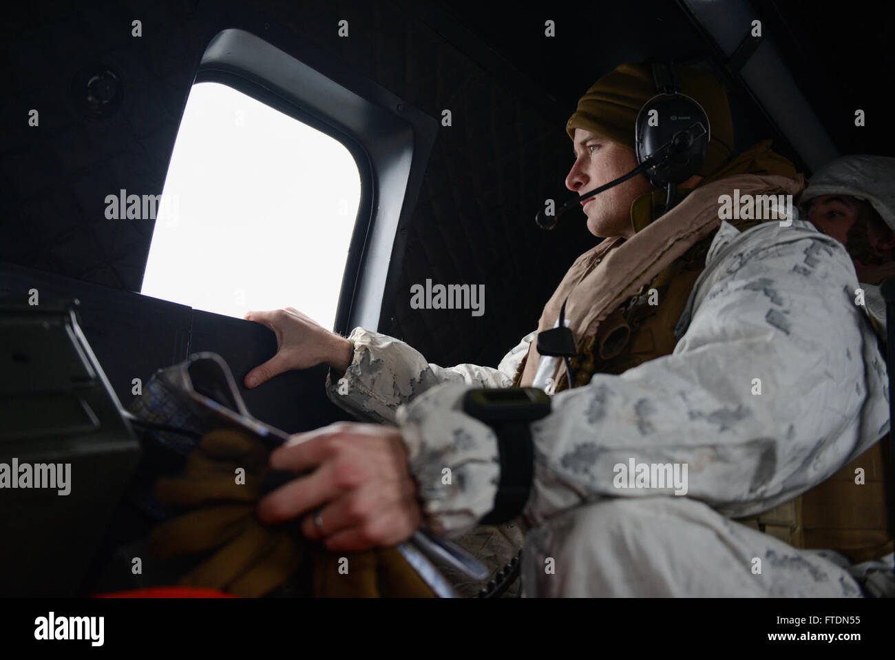 160307-N-QJ850-478 NORTH SEA (March 7, 2016) Lt. Col. David W. Baas, commander of troops of the 2nd Assault Amphibian Battalion, looks out the window of a Netherlands NH90 helicopter during Exercise Cold Response 2016 (CDR 16). CDR 16 involves maritime, land and air operation training and focuses on naval and amphibious operations transitioning to ground maneuver. The location in central Norway provides an extreme cold-weather environment for the 12 participating countries to collectively develop tactics, techniques and procedures and increase interoperability. (U.S. Navy photo by Mass Communi Stock Photo