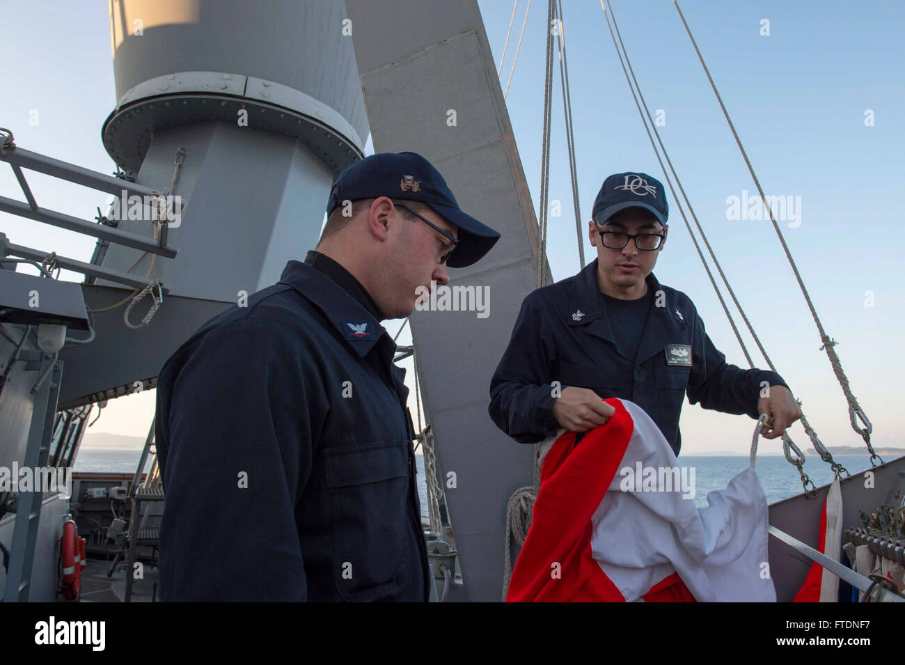 160319-N-TC720-041 ADRIATIC SEA (March 19, 2016) Operations Specialist 1st Class William Trent, from Wichita Falls, Texas, trains Operations Specialist 3rd Class Matthew McKeever, from Jersey City, New Jersey on ship’s flags, aboard USS Donald Cook (DDG 75) Mar. 19, 2016. Donald Cook, an Arleigh Burke-class guided-missile destroyer, forward deployed to Rota, Spain is conducting a routine patrol in the U.S. 6th Fleet area of operations in support of U.S. national security interests in Europe. (U.S. Navy photo by Mass Communication Specialist 2nd Class Mat Murch/Released) Stock Photo