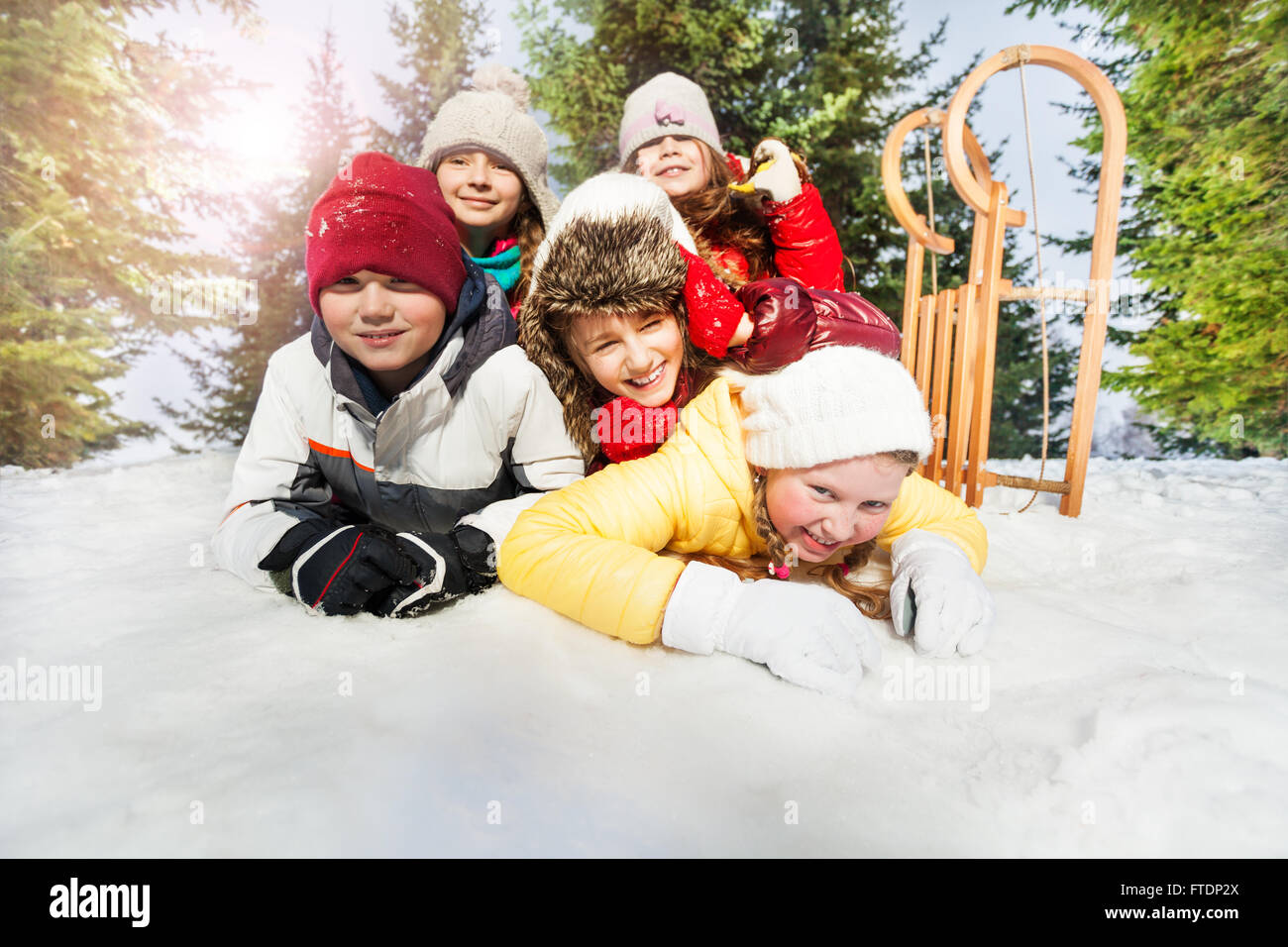 Group of children playing on snow in winter time Stock Photo - Alamy